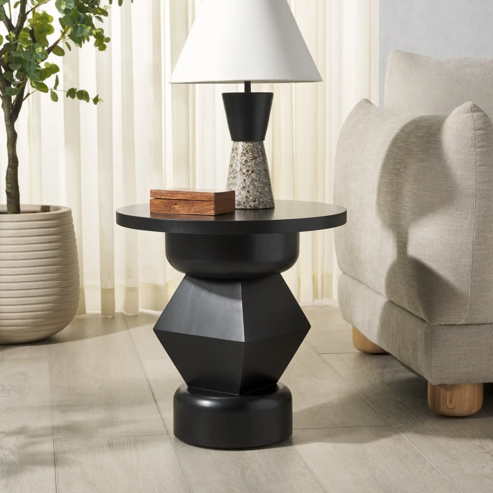 Jaymee Round Wood Accent Table in Black in a styled room