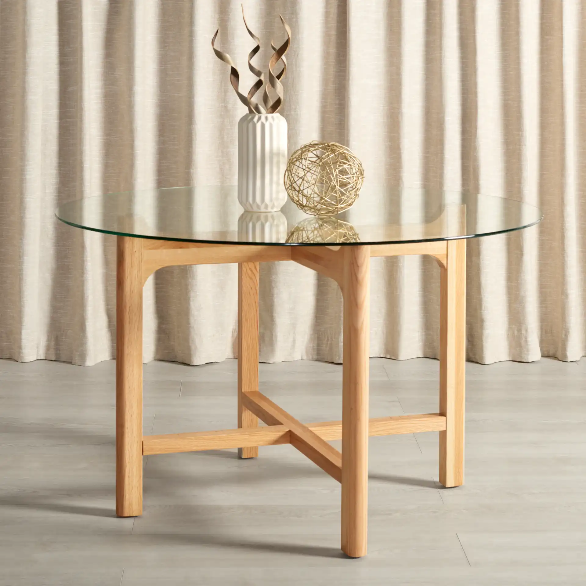 Ruthanne Round Glass Dining Table in Clear / Oak in a styled room