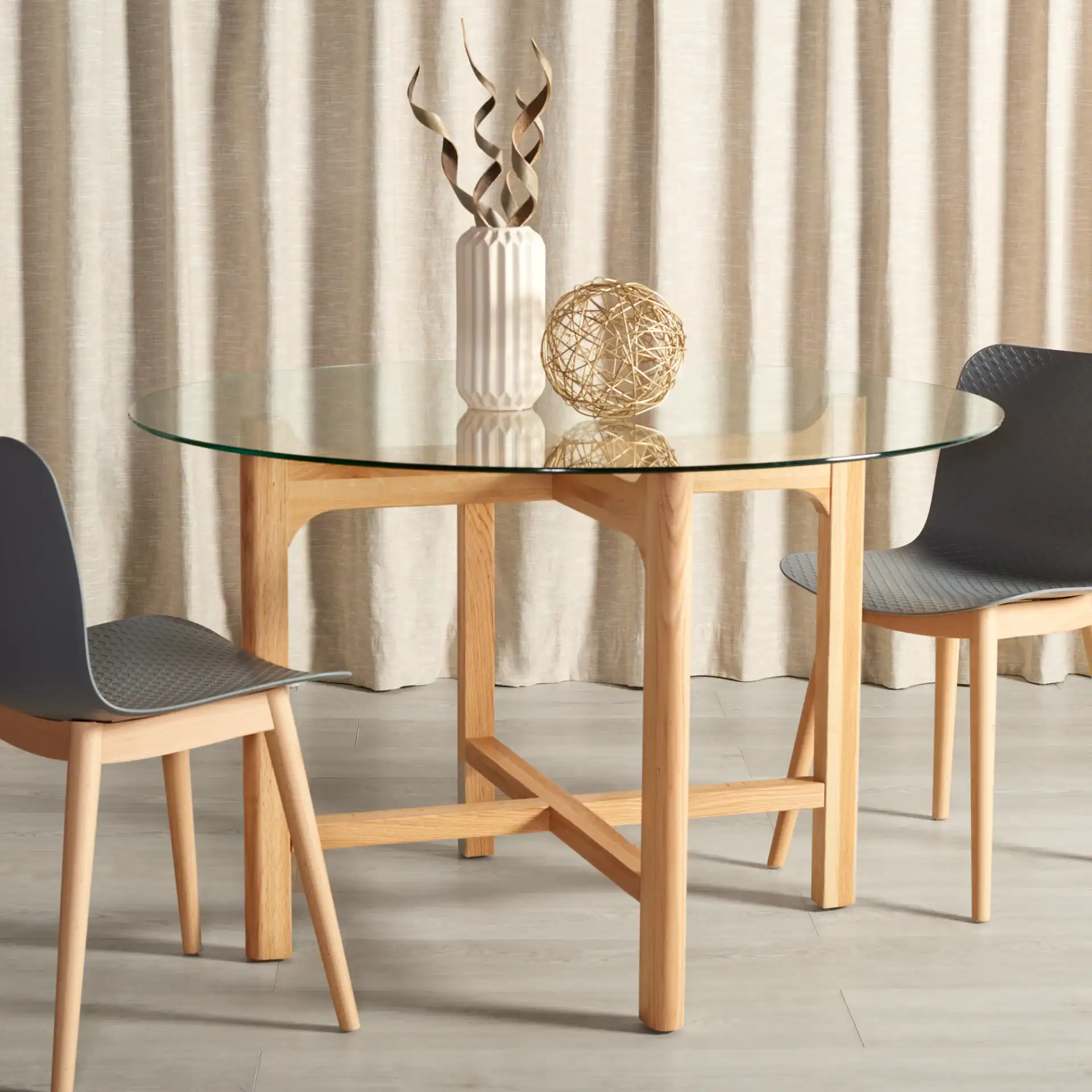 Ruthanne Round Glass Dining Table in Clear / Oak in a styled room