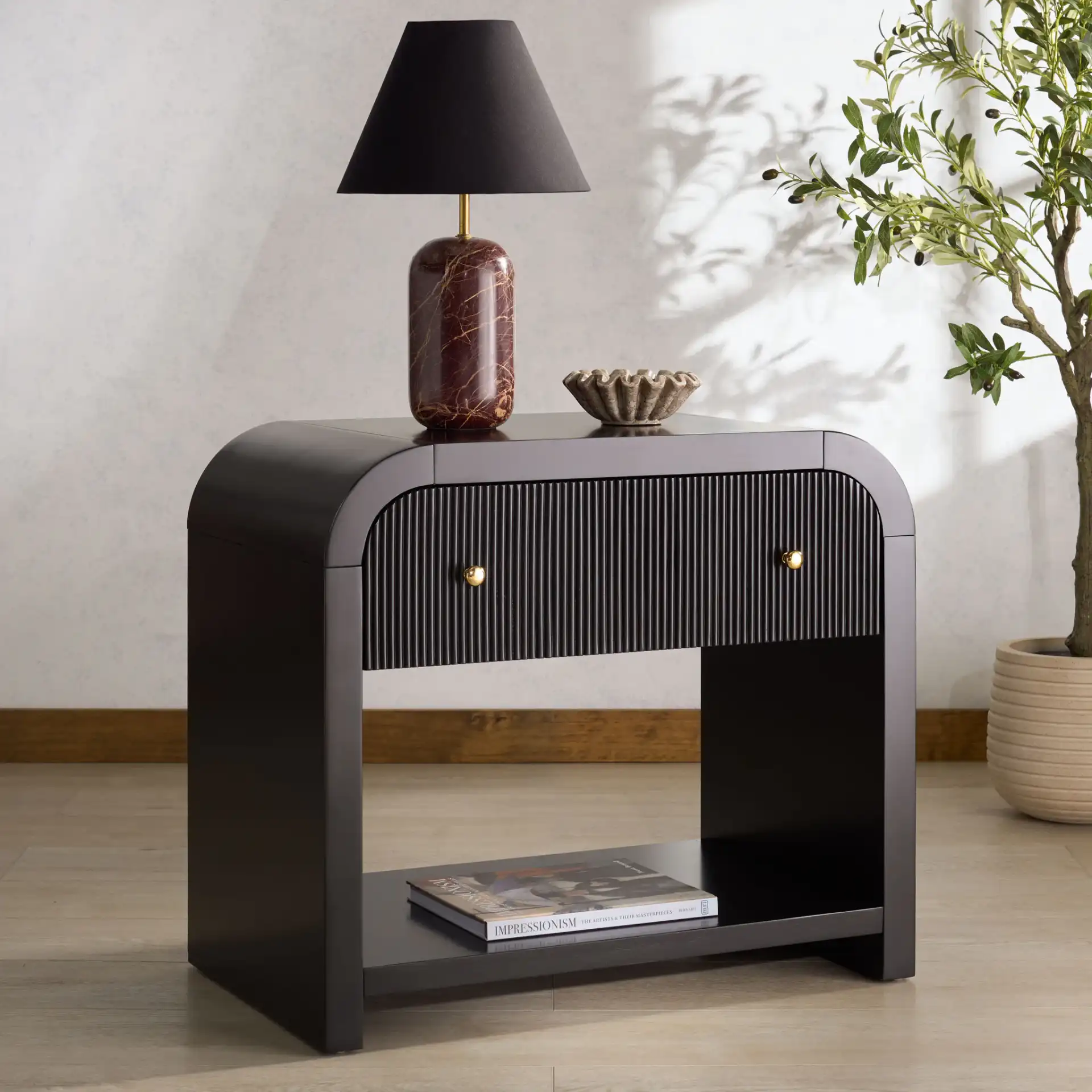 Liabella One-Drawer Curved Nightstand in Black / Gold in a styled room