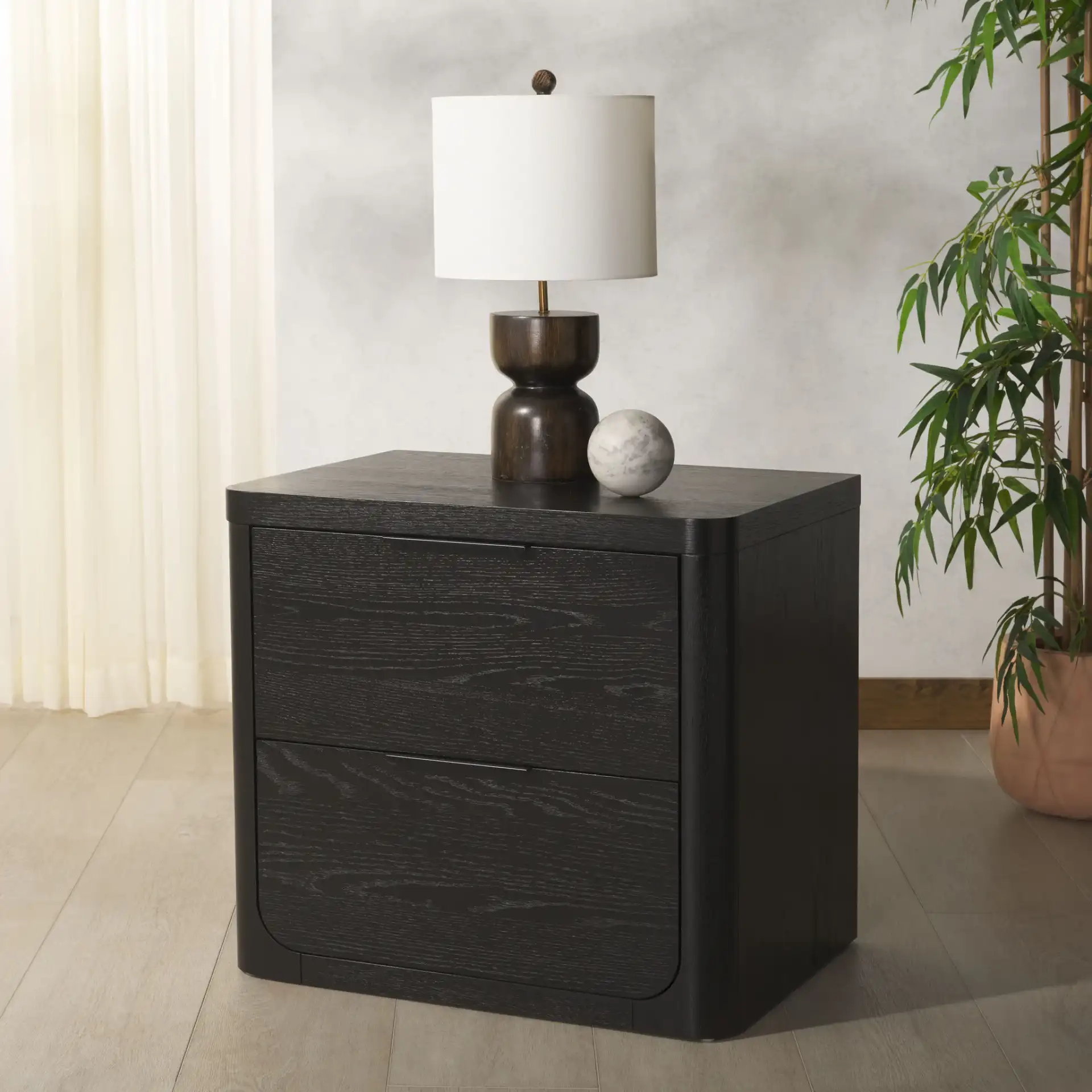 Raylie Two-Drawer Wood Nightstand in Black in a styled room
