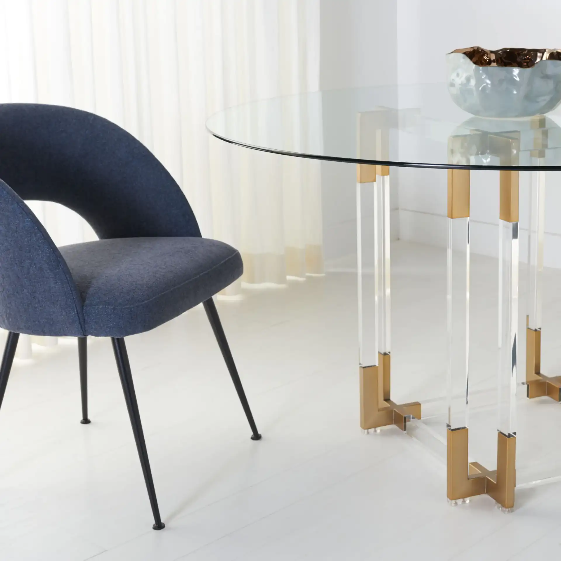 Koryn Round Dining Table in Clear / Brass in a styled room