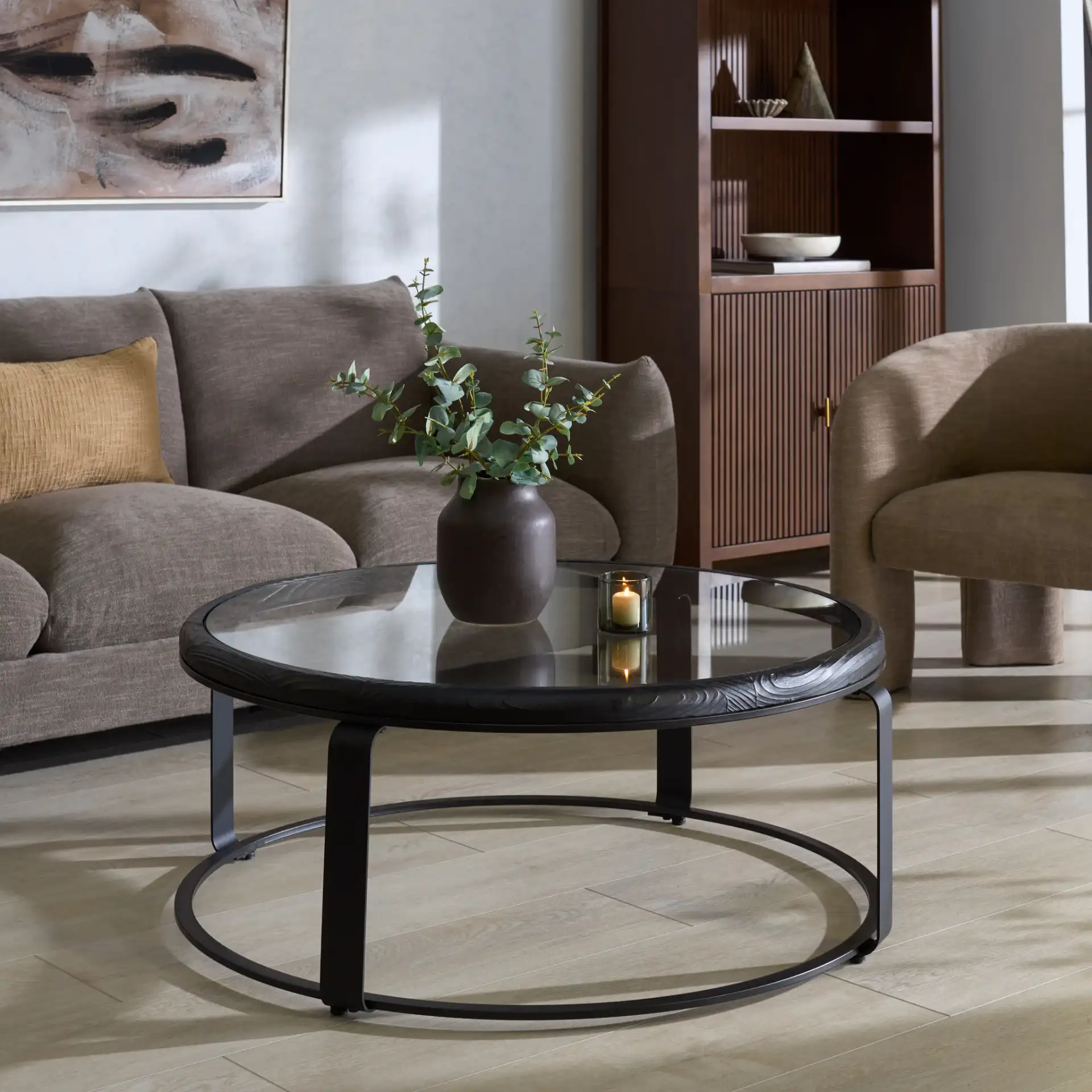 Tyrese Metal Round Coffee Table in Black / Clear in a styled room