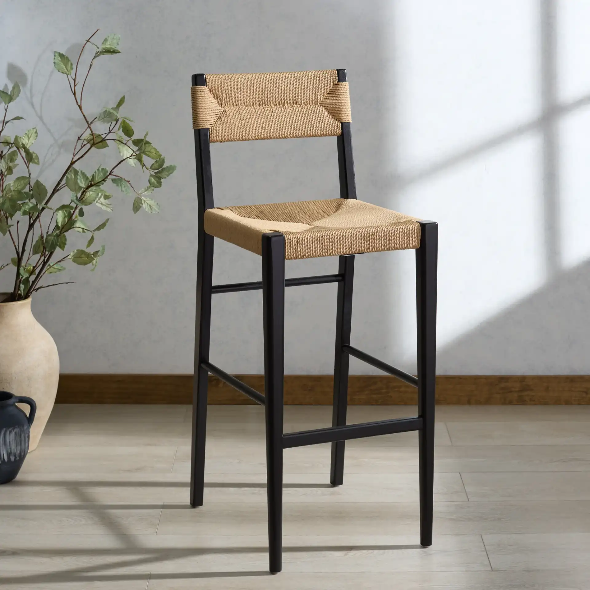 Cody Rattan Barstool in Black / Natural in a styled room