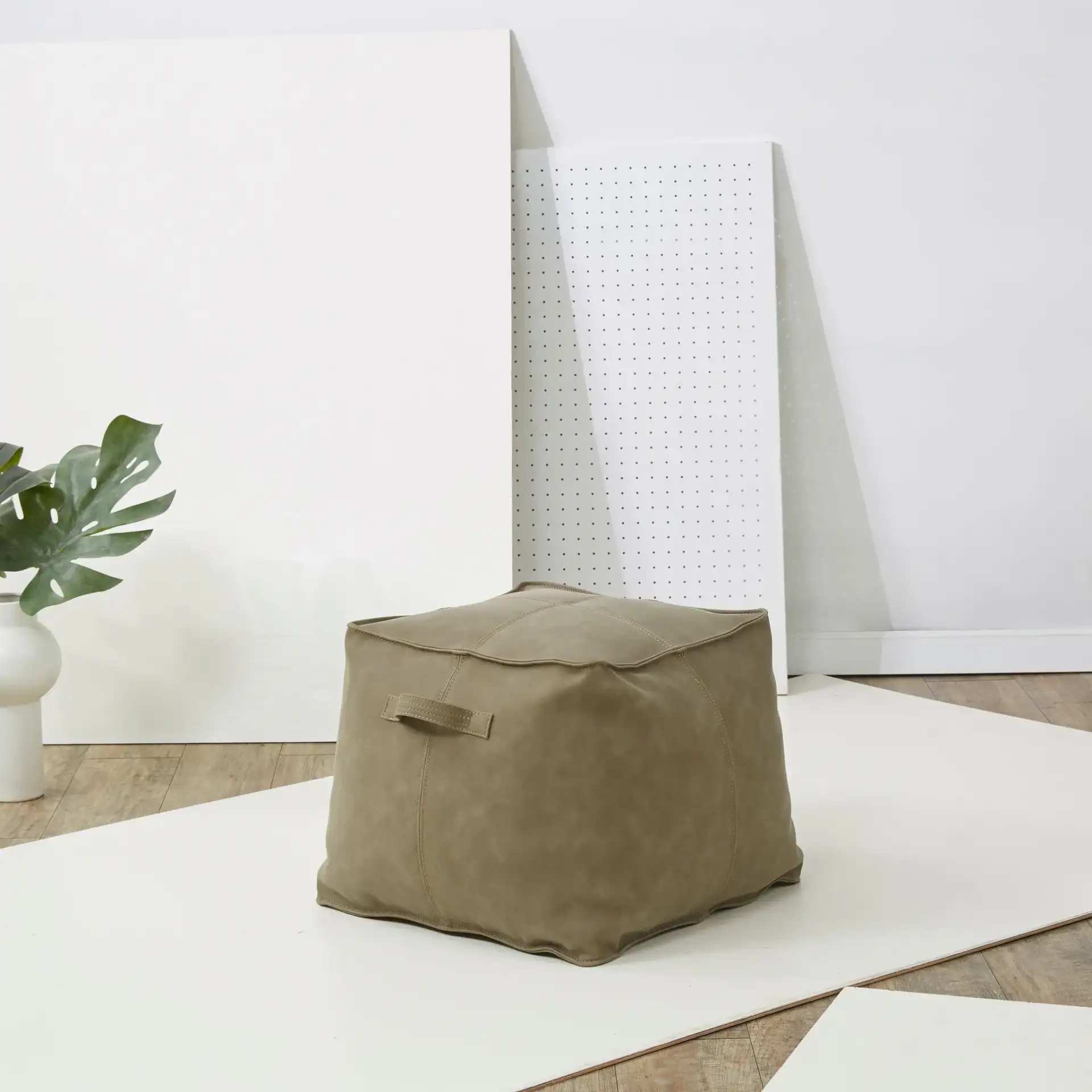 Pablo Vegan Leather Pouf in Brown in a styled room