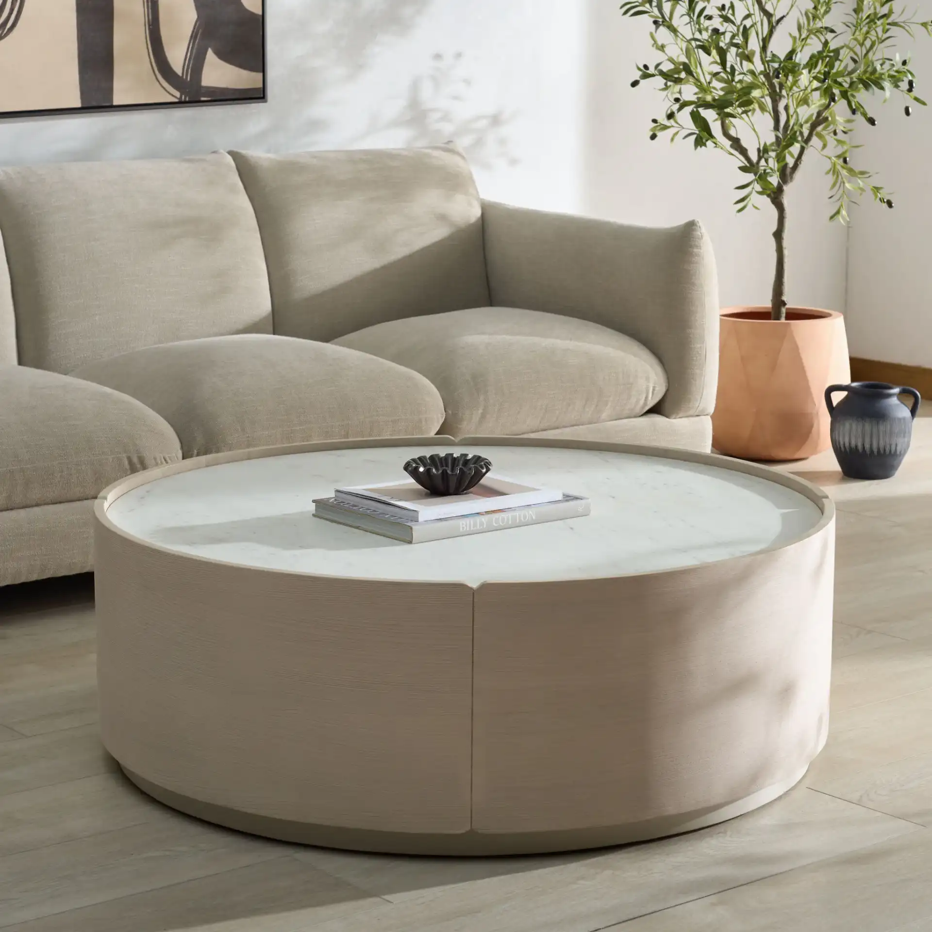 Alanabella Marble Round Coffee Table in Sand / White in a styled room