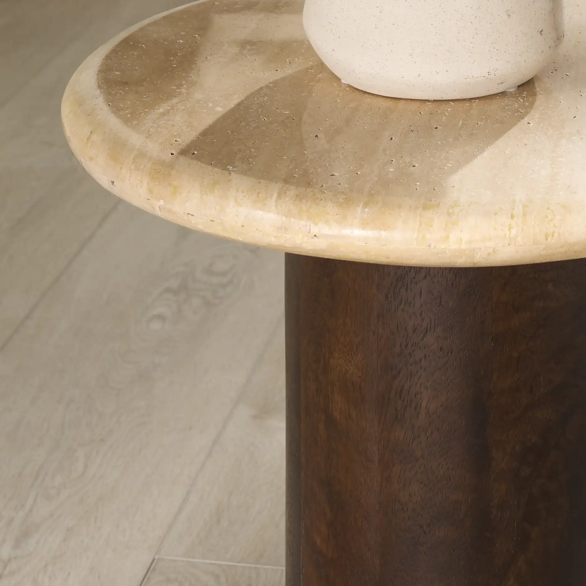 Jennamira Round Travertine Table in Dark Brown / Travertine in a styled room