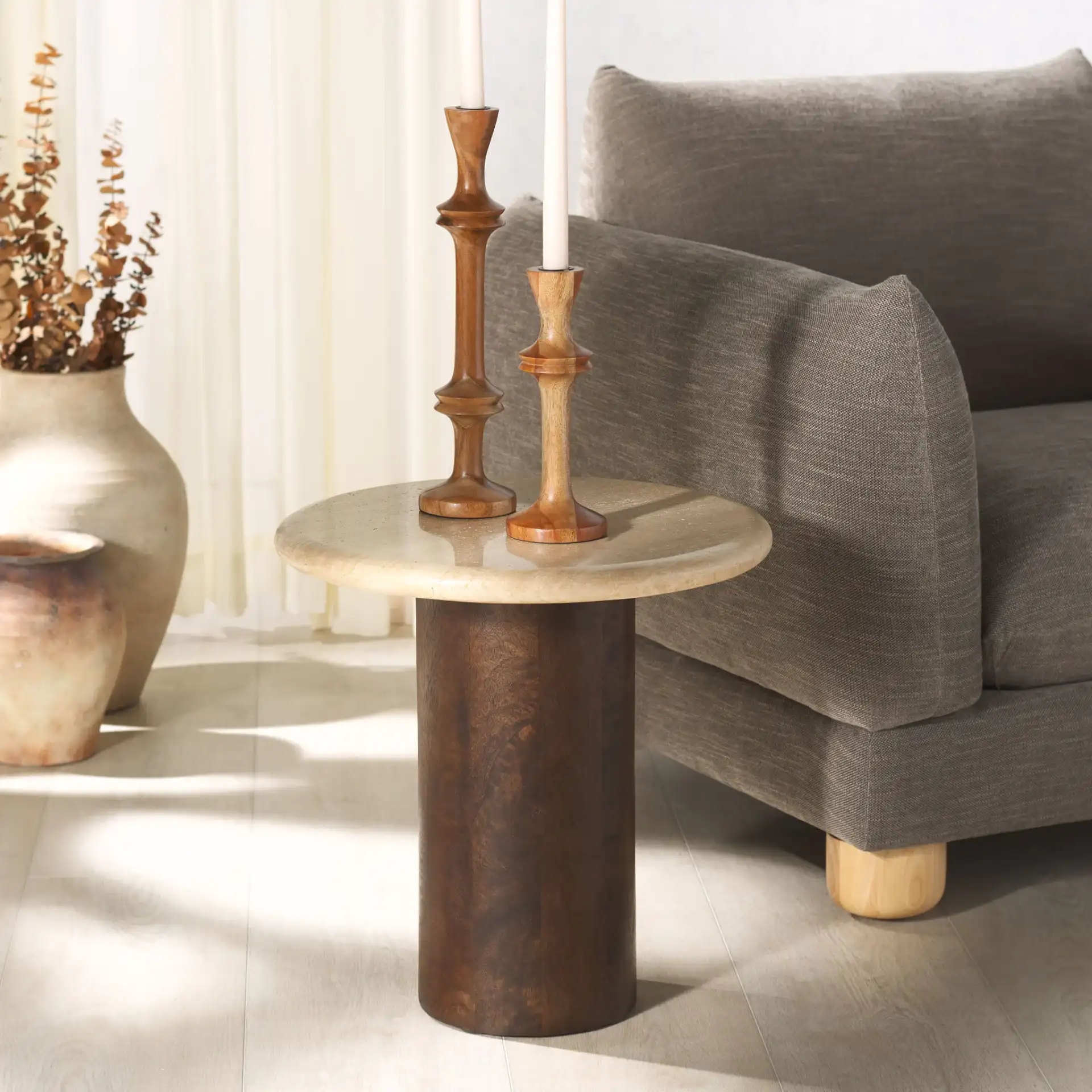 Jennamira Round Travertine Table in Dark Brown / Travertine in a styled room
