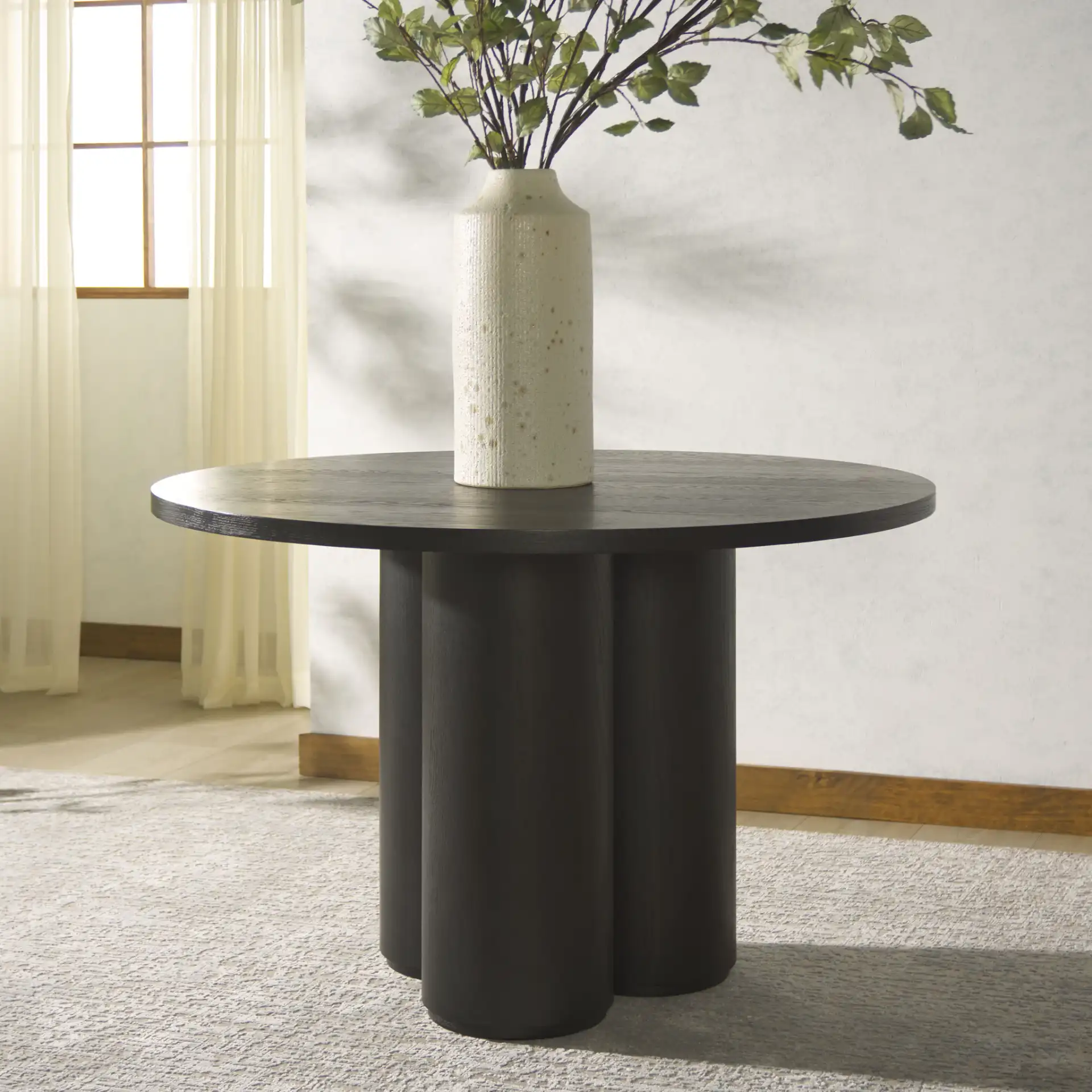 Kathalina Round Wood Dining Table in Black in a styled room