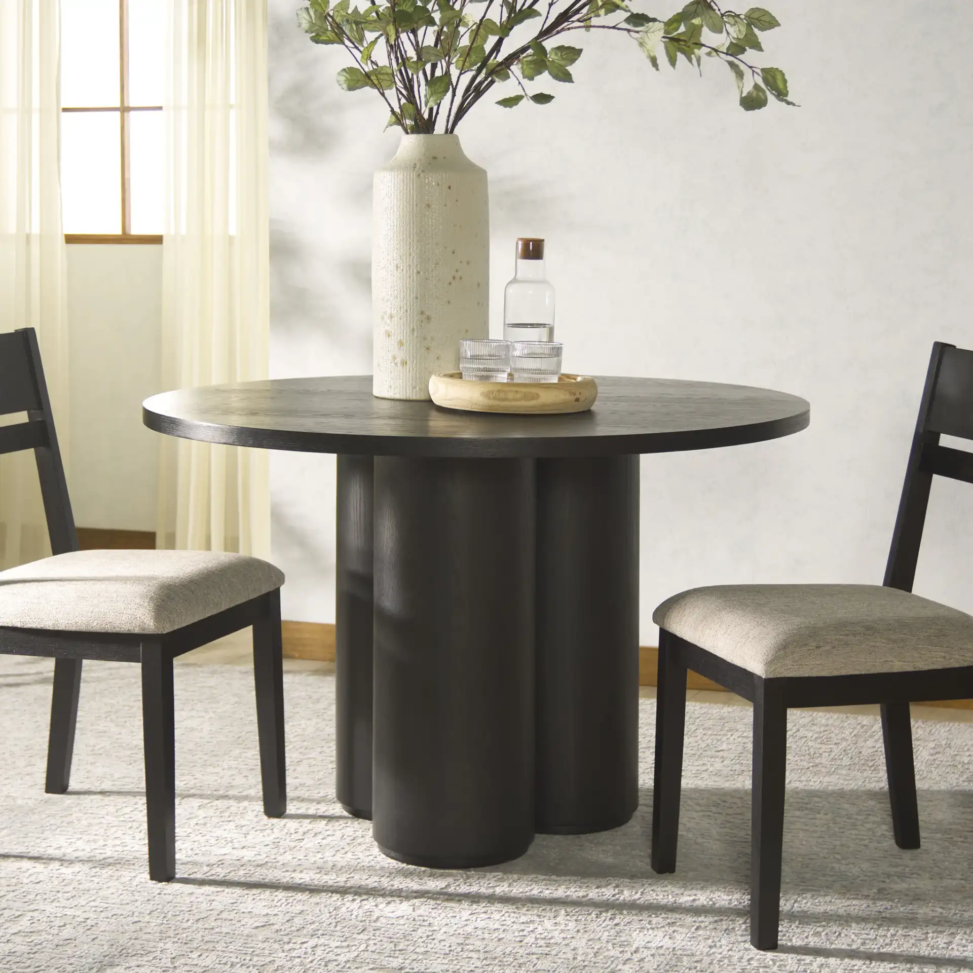 Kathalina Round Wood Dining Table in Black in a styled room
