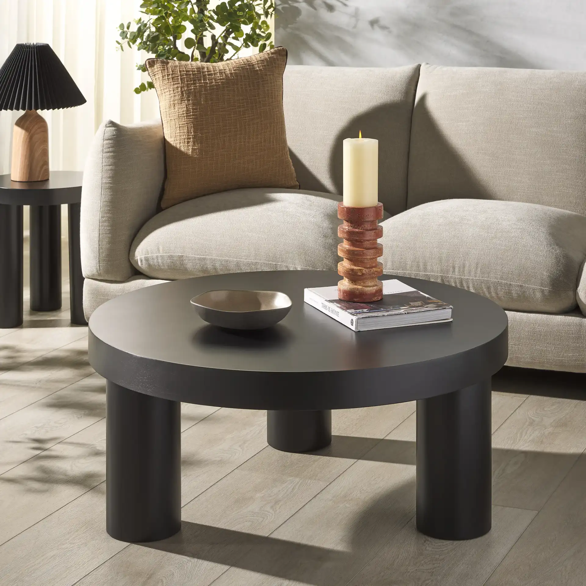Bary Round Three-Leg Wood Coffee Table in Black in a styled room