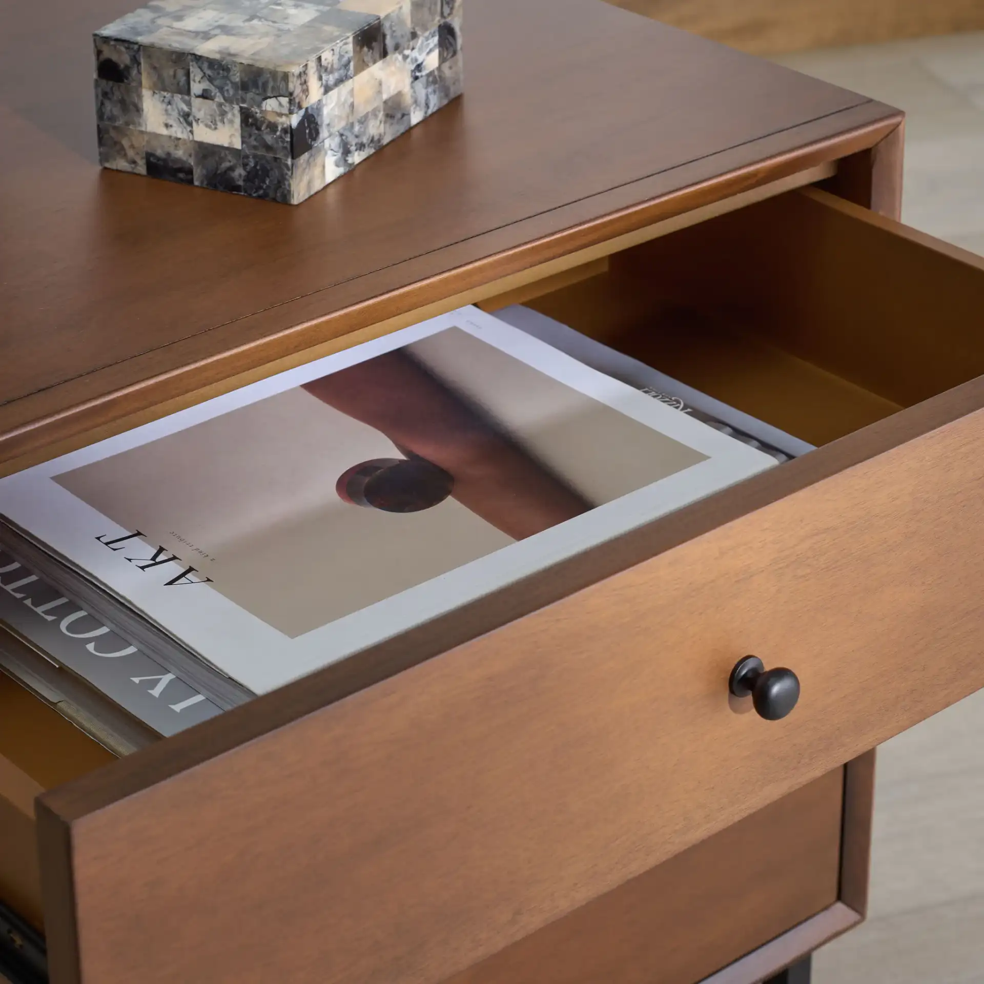 Trever Wood Three-Drawer Nightstand in Walnut / Black in a styled room