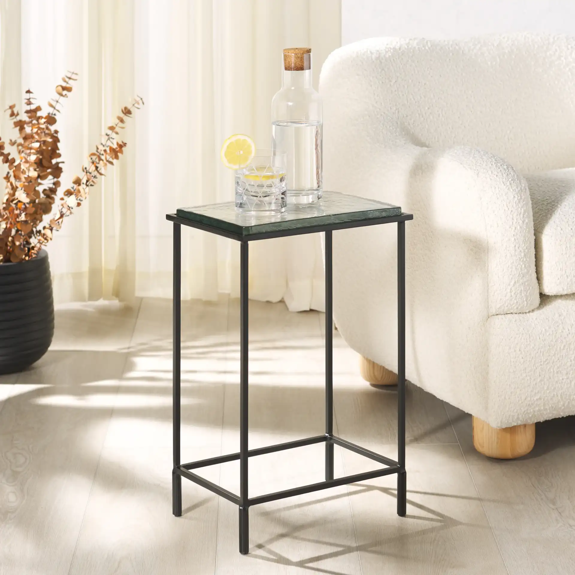 Ferguson Cast Glass Accent Table in Black / Clear in a styled room