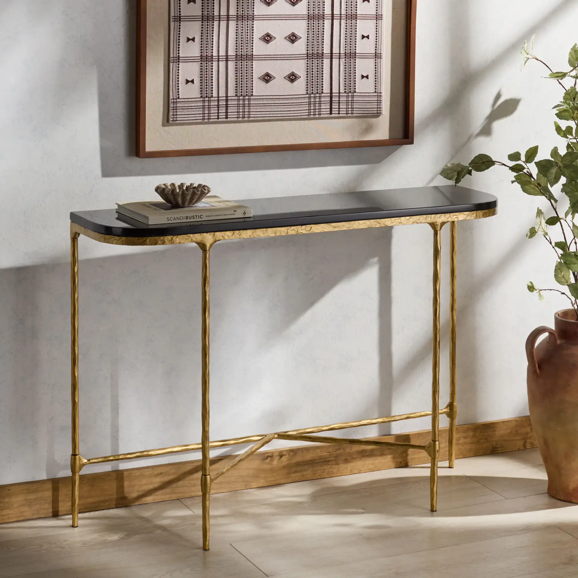 Janowsky Metal Console Table in Brass / Black in a styled room
