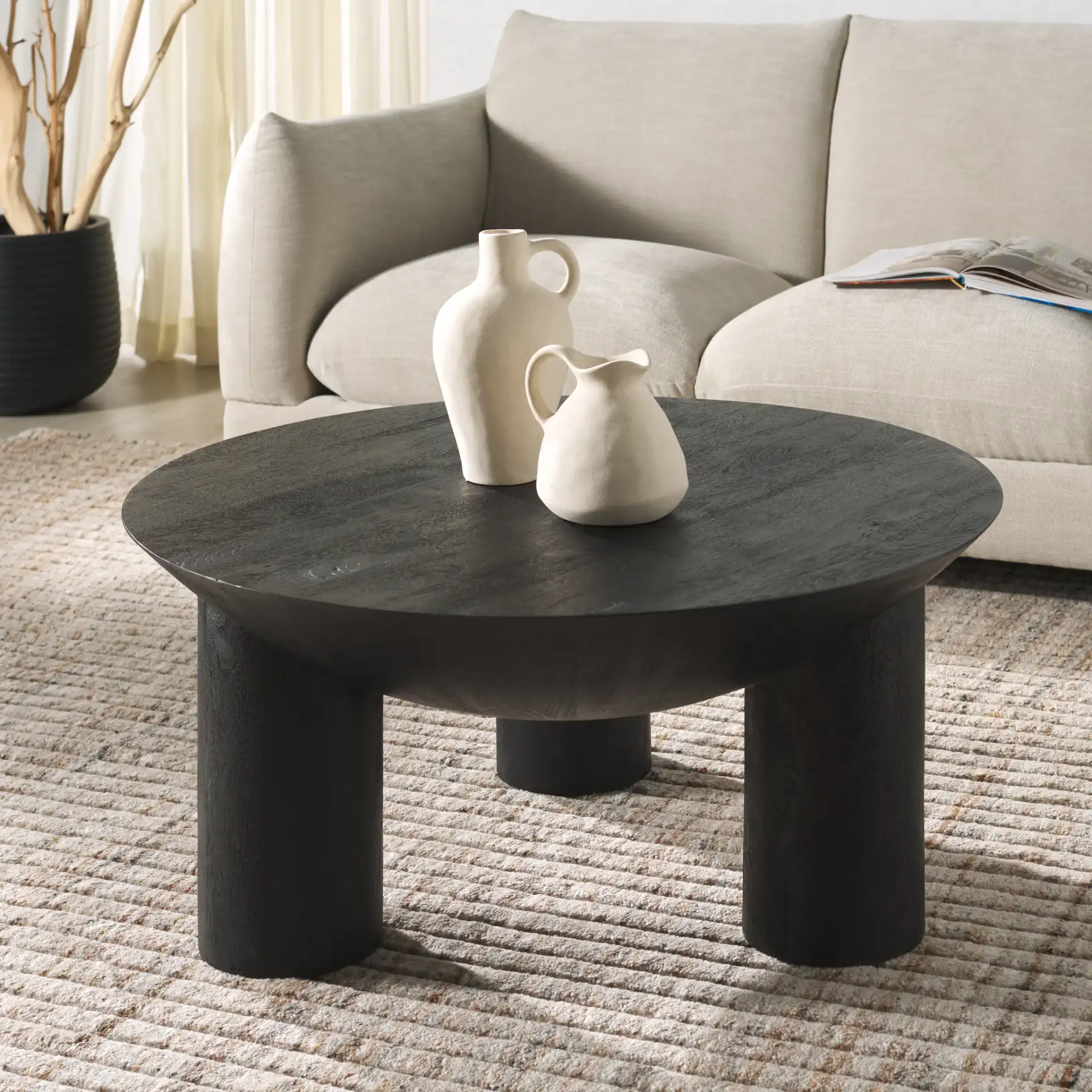 Calhoun Round Wood Coffee Table in Black in a styled room