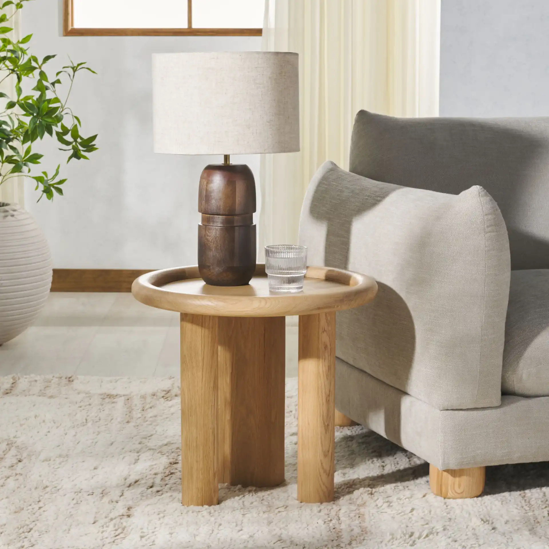 Madelynn Round Wood Accent Table in Natural in a styled room