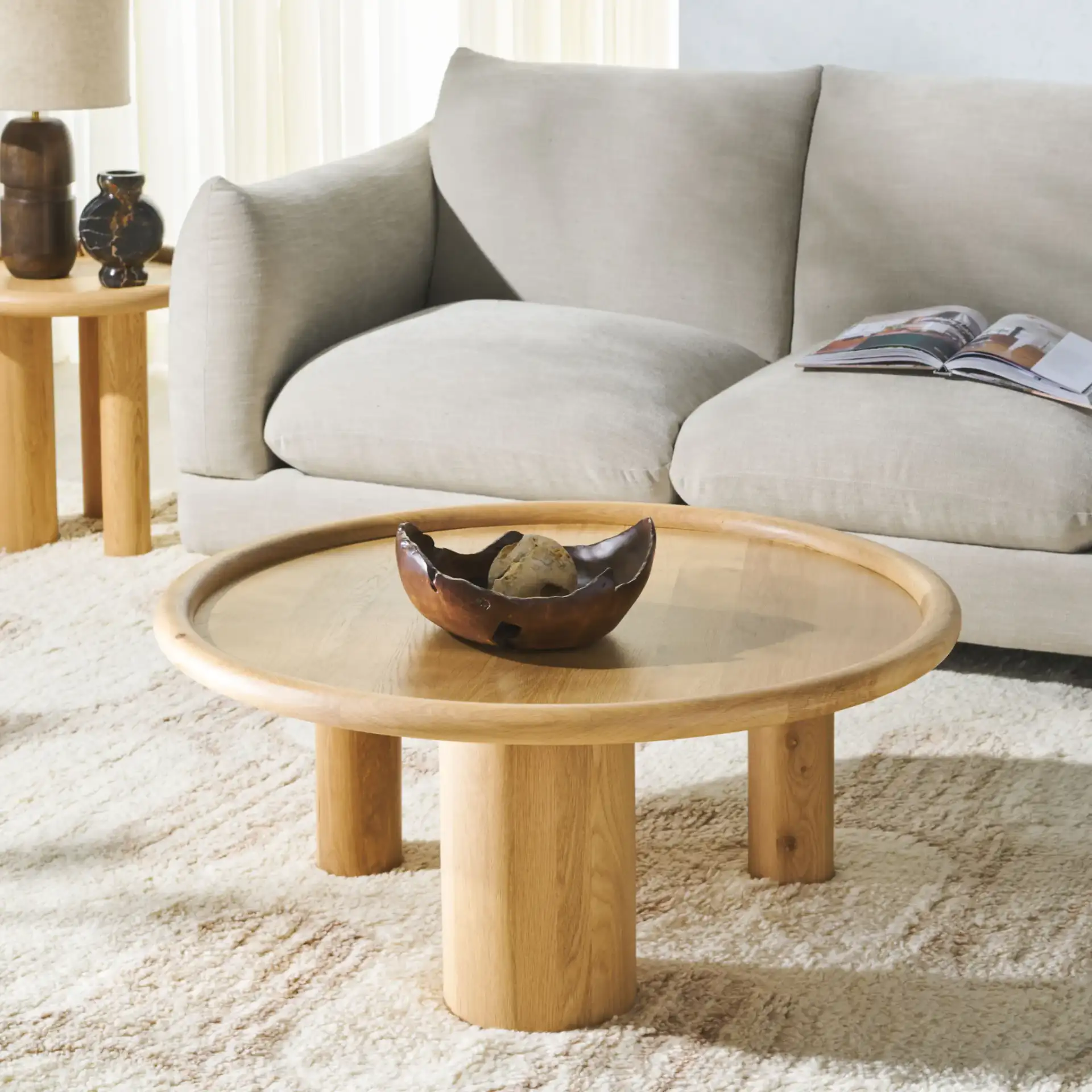Madelynn Round Wood Coffee Table in Natural in a styled room