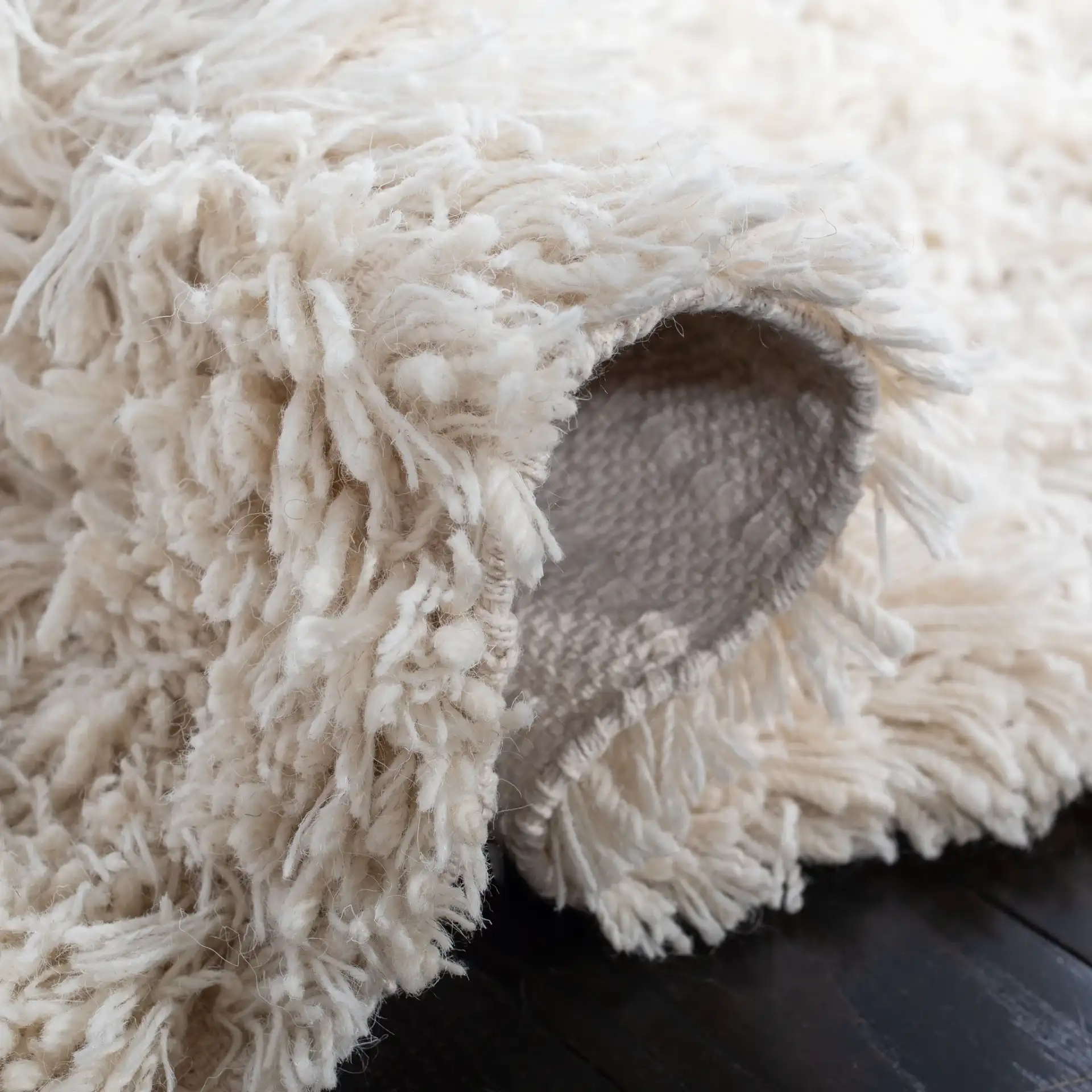 Carmel Solid Hand-Woven Wool Shag Rug in Ivory in a styled room
