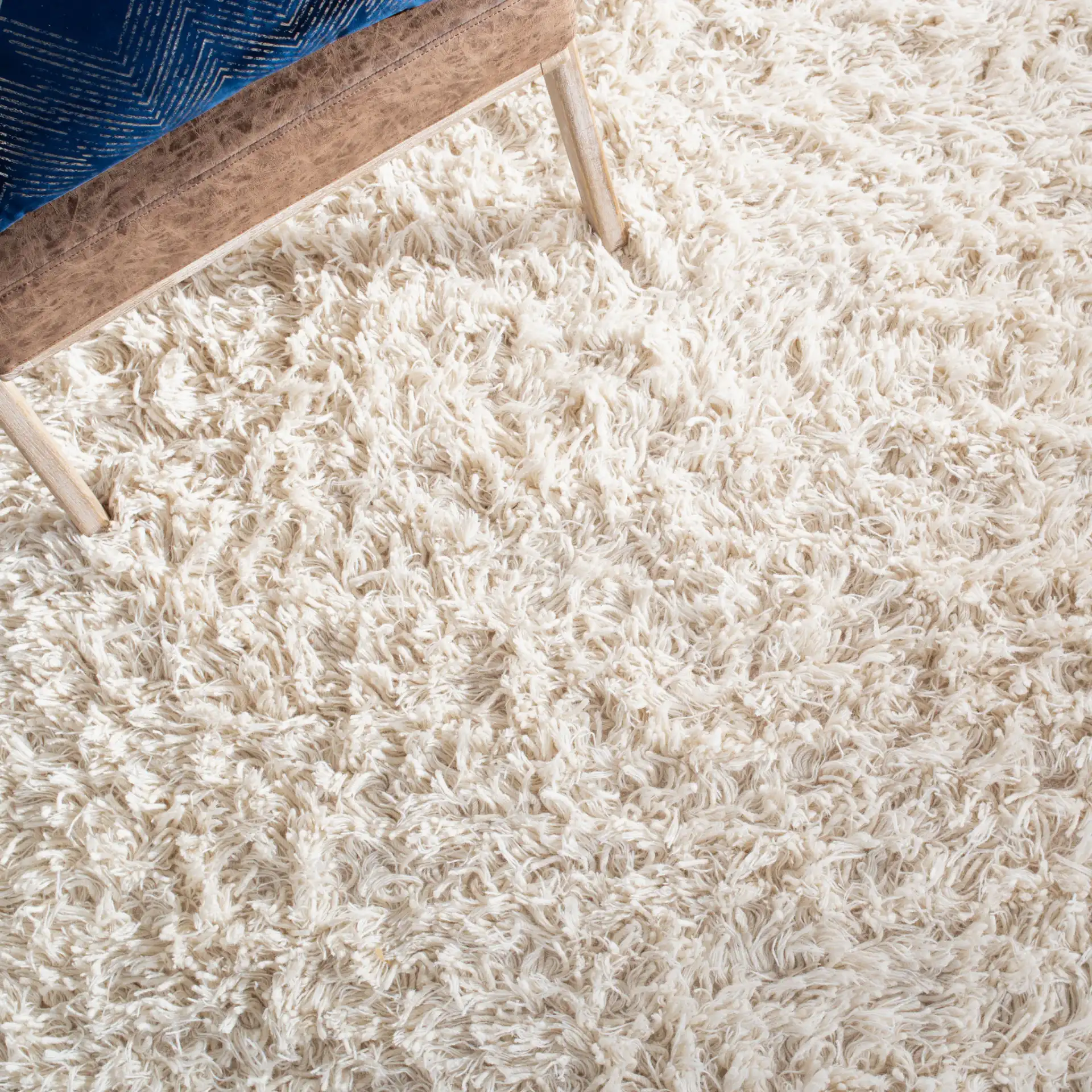 Carmel Solid Hand-Woven Wool Shag Rug in Ivory in a styled room