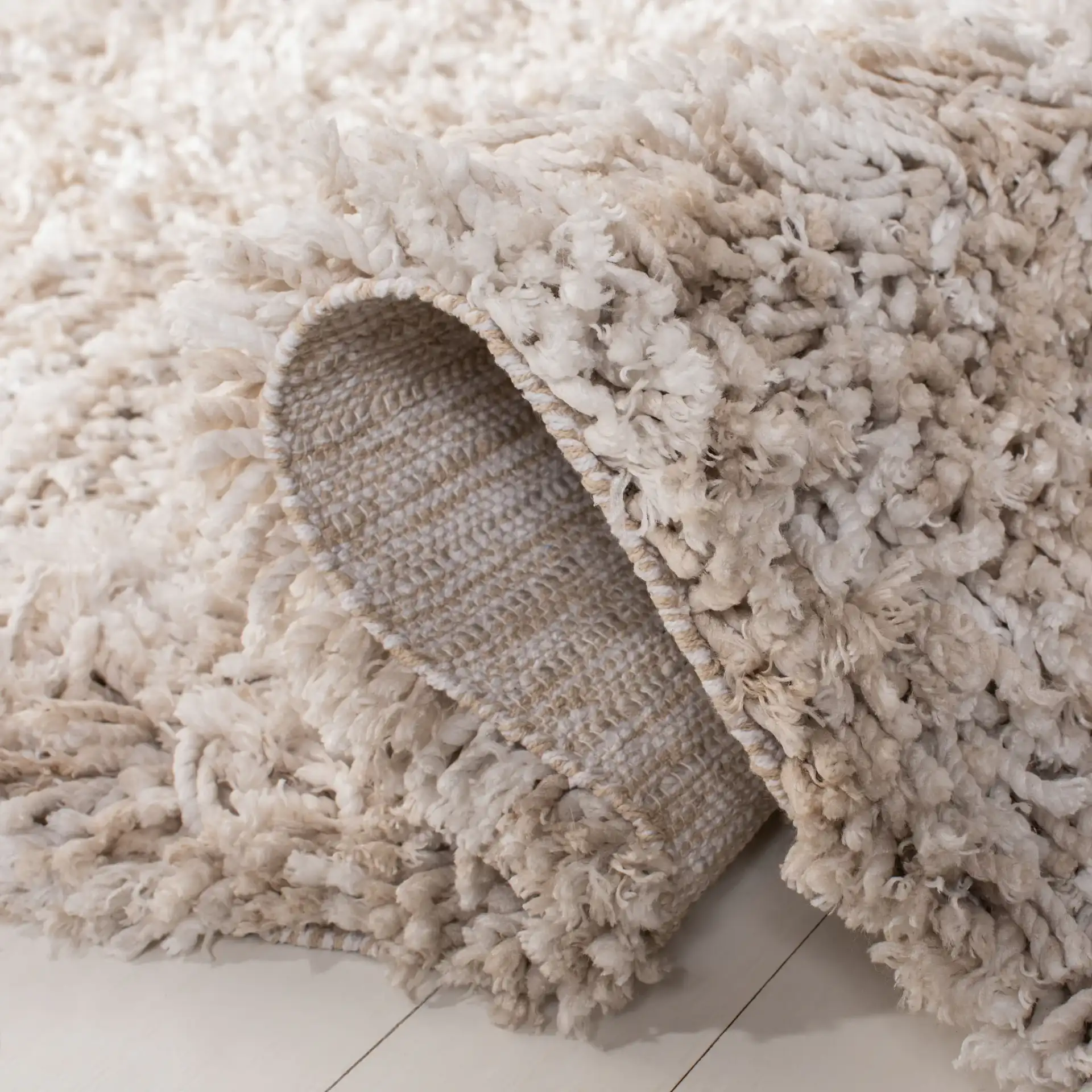 Rio Solid Hand-Loomed Shag Rug in Beige / Ivory in a styled room