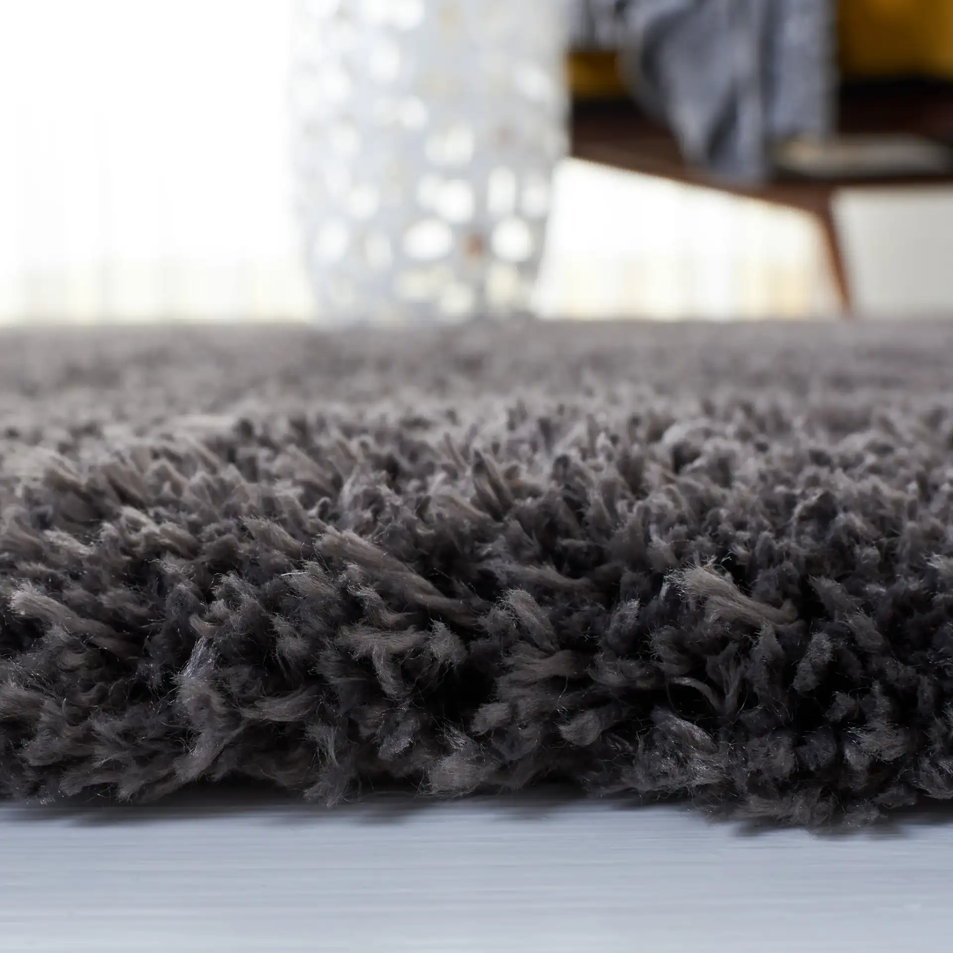 Reno Solid Shag Rug in Dark Gray in a styled room