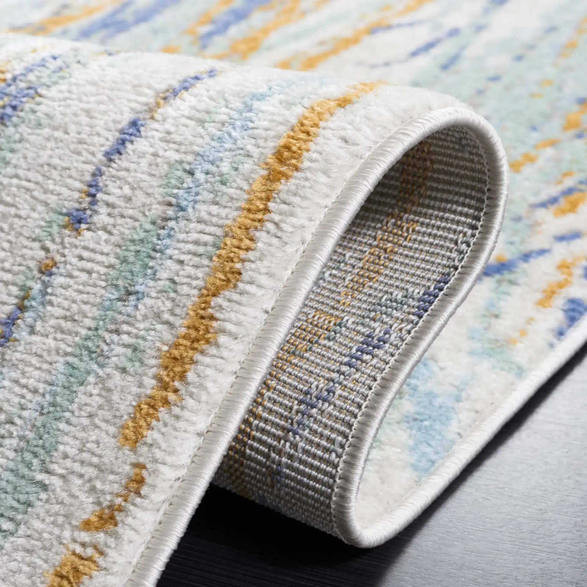 Skyler Abstract Dappled Linear Rug in Gold / Blue Green in a styled room