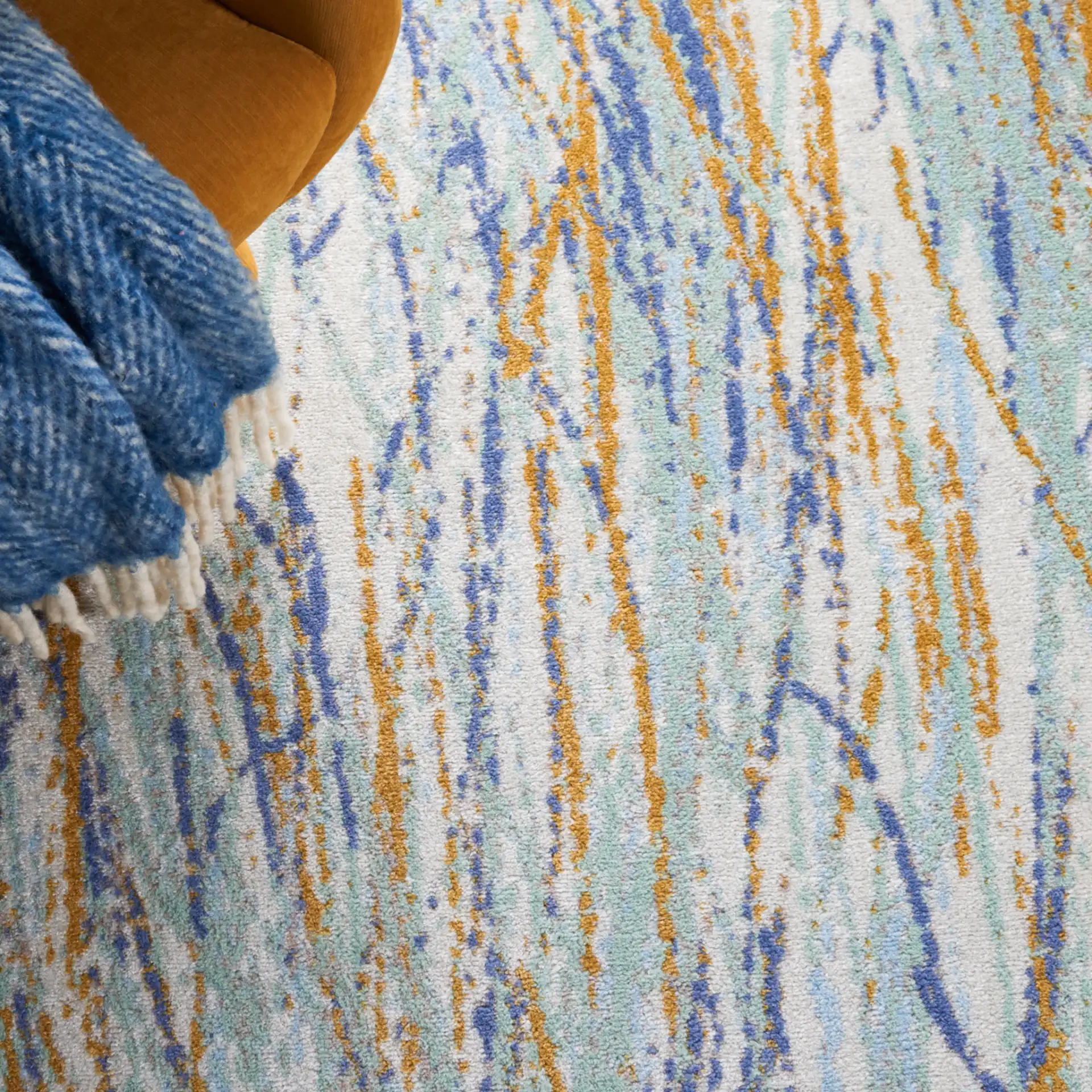Skyler Abstract Dappled Linear Rug in Gold / Blue Green in a styled room