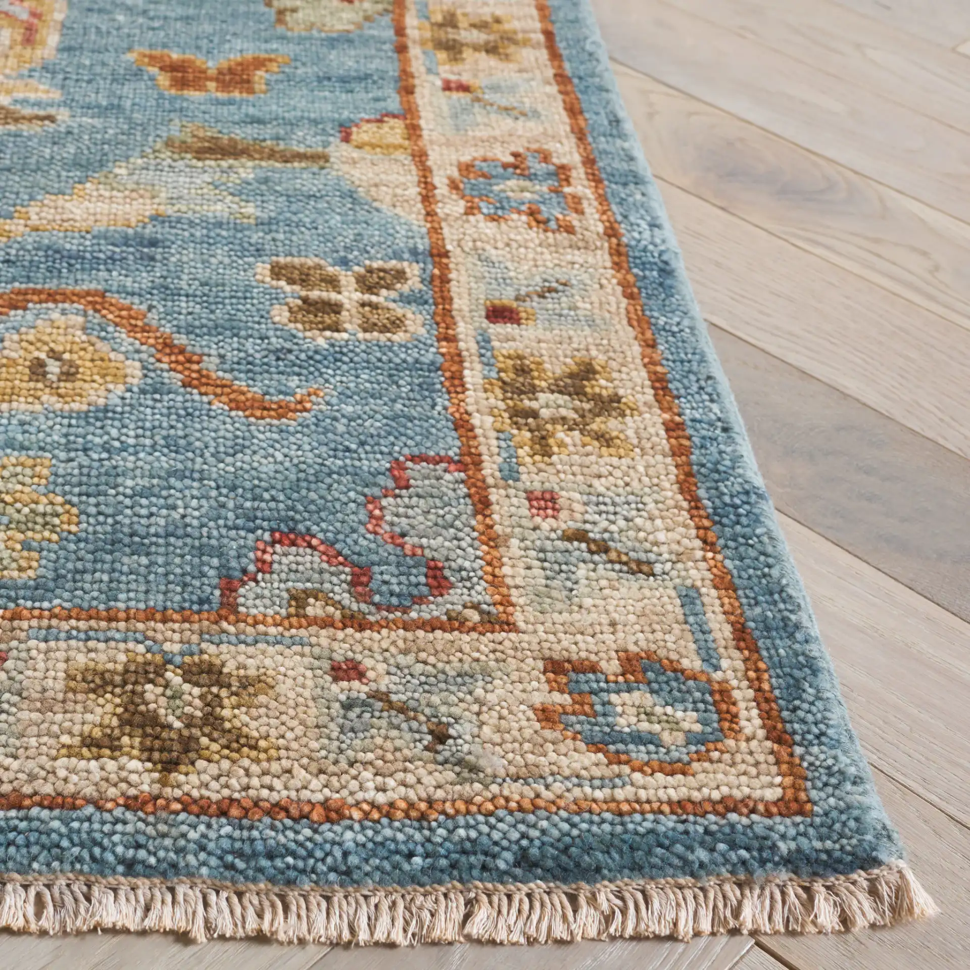 Samarkand Palmette Floral Bordered Hand-Knotted Wool Rug in Blue in a styled room
