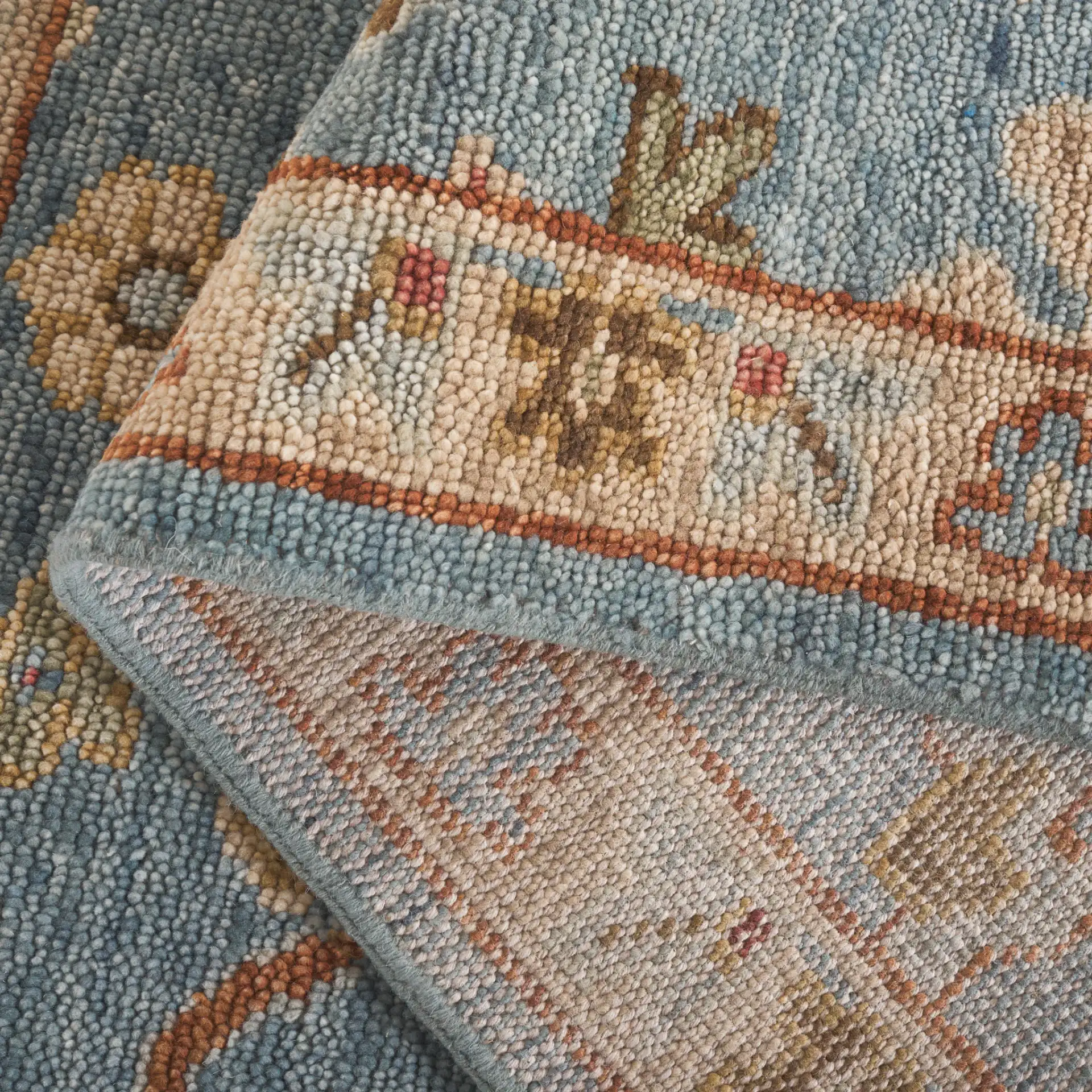 Samarkand Palmette Floral Bordered Hand-Knotted Wool Rug in Blue in a styled room