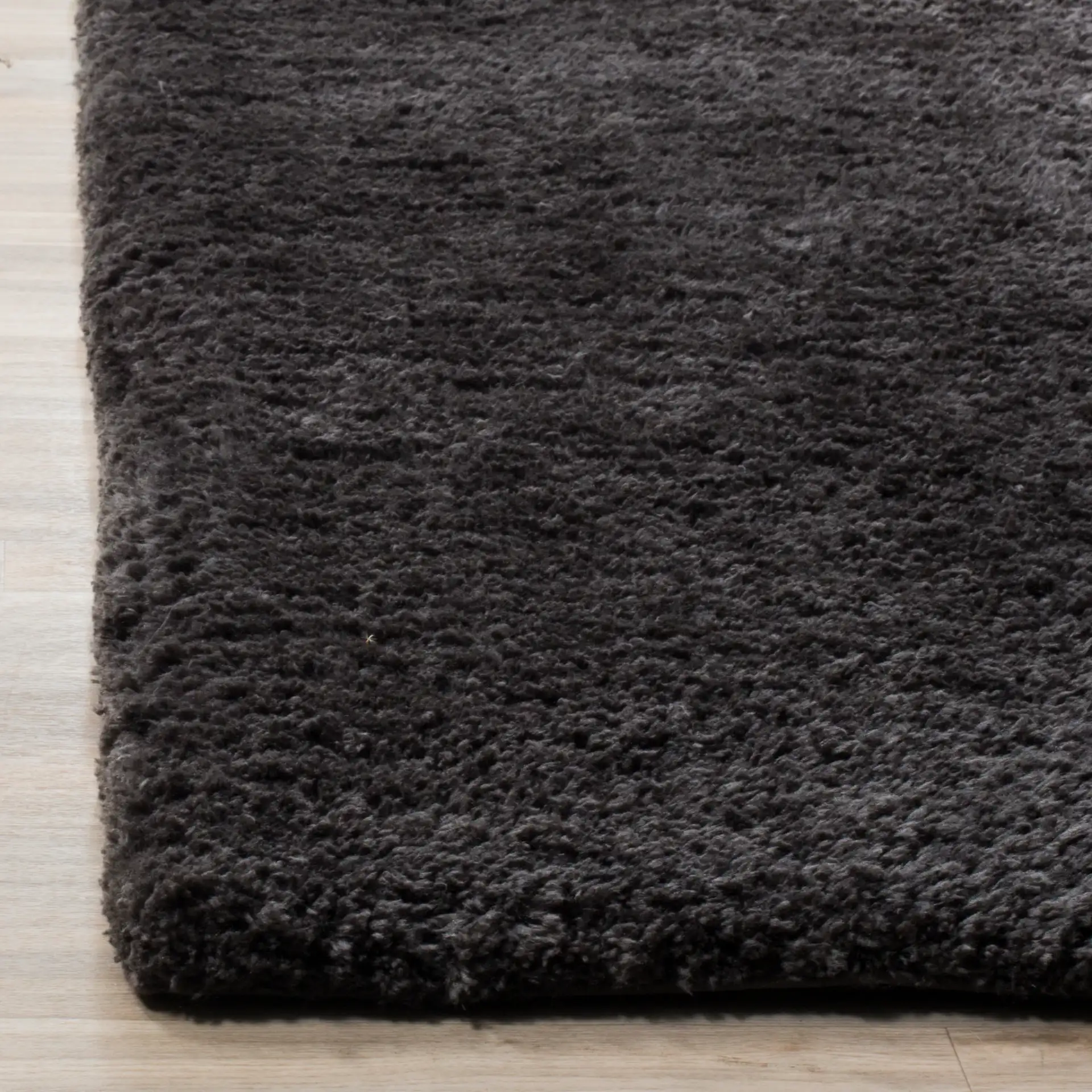 Sheep Solid Hand-Woven Shag Rug in Charcoal in a styled room