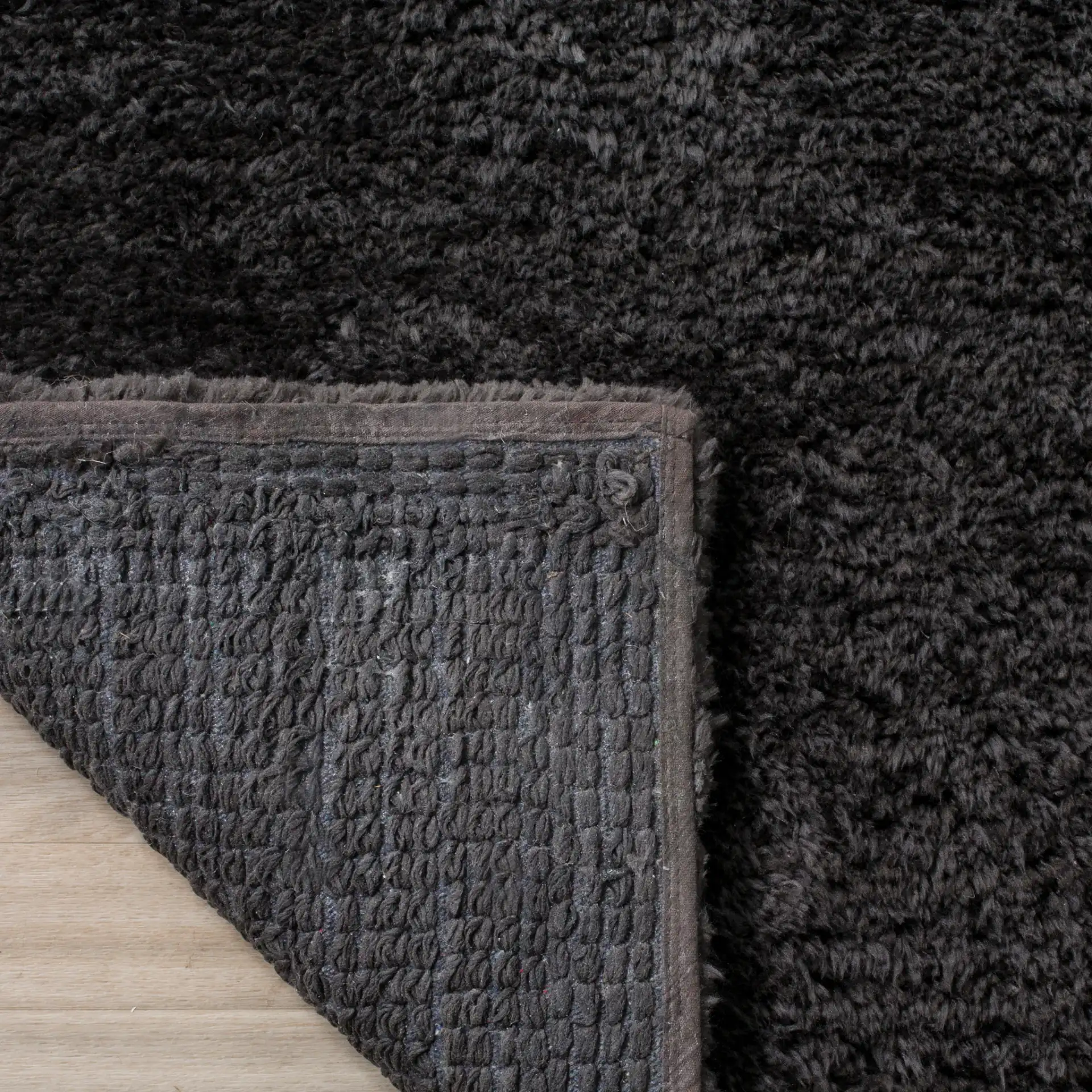 Sheep Solid Hand-Woven Shag Rug in Charcoal in a styled room