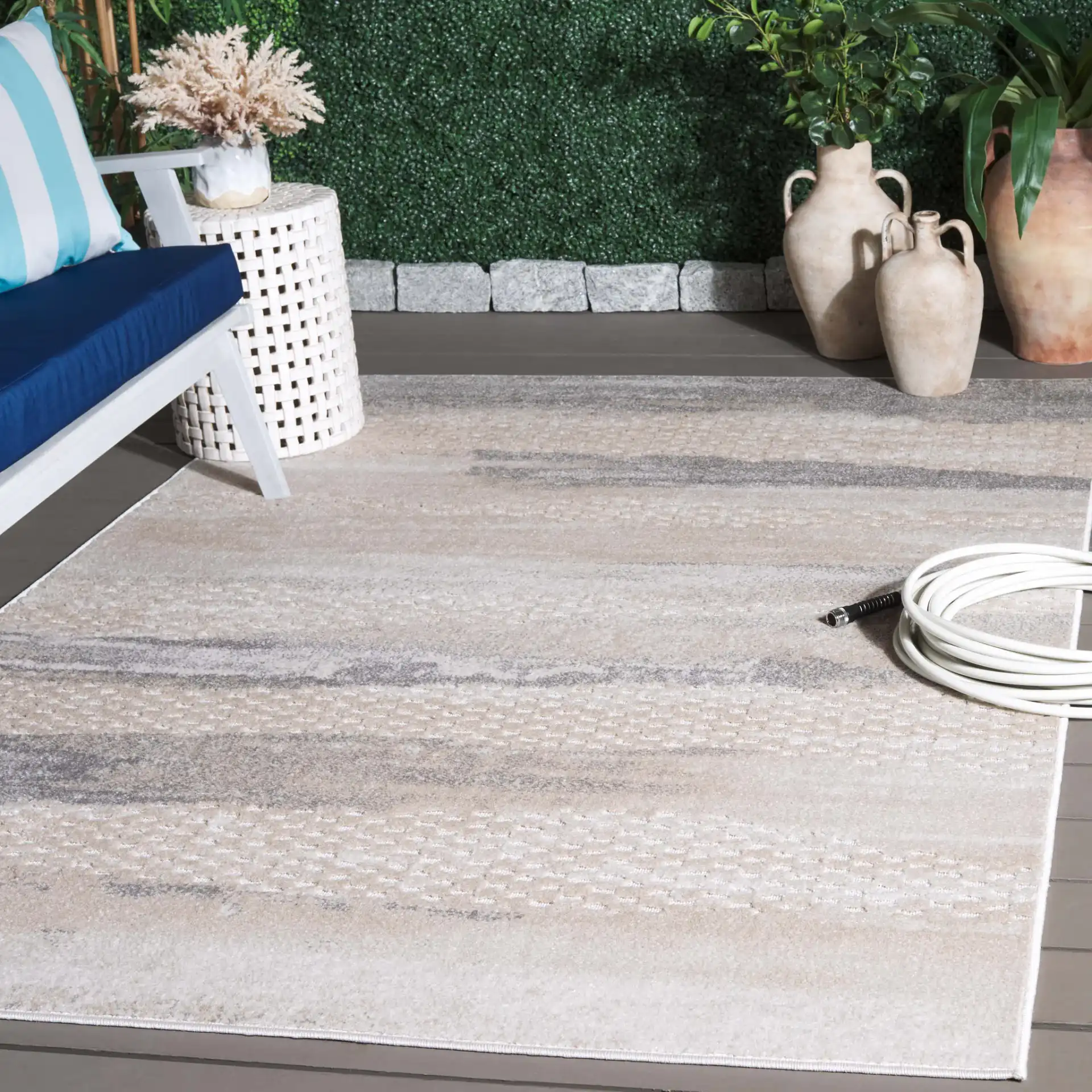 Stella Banded Abstract Outdoor Rug in Beige / Gray in a styled room