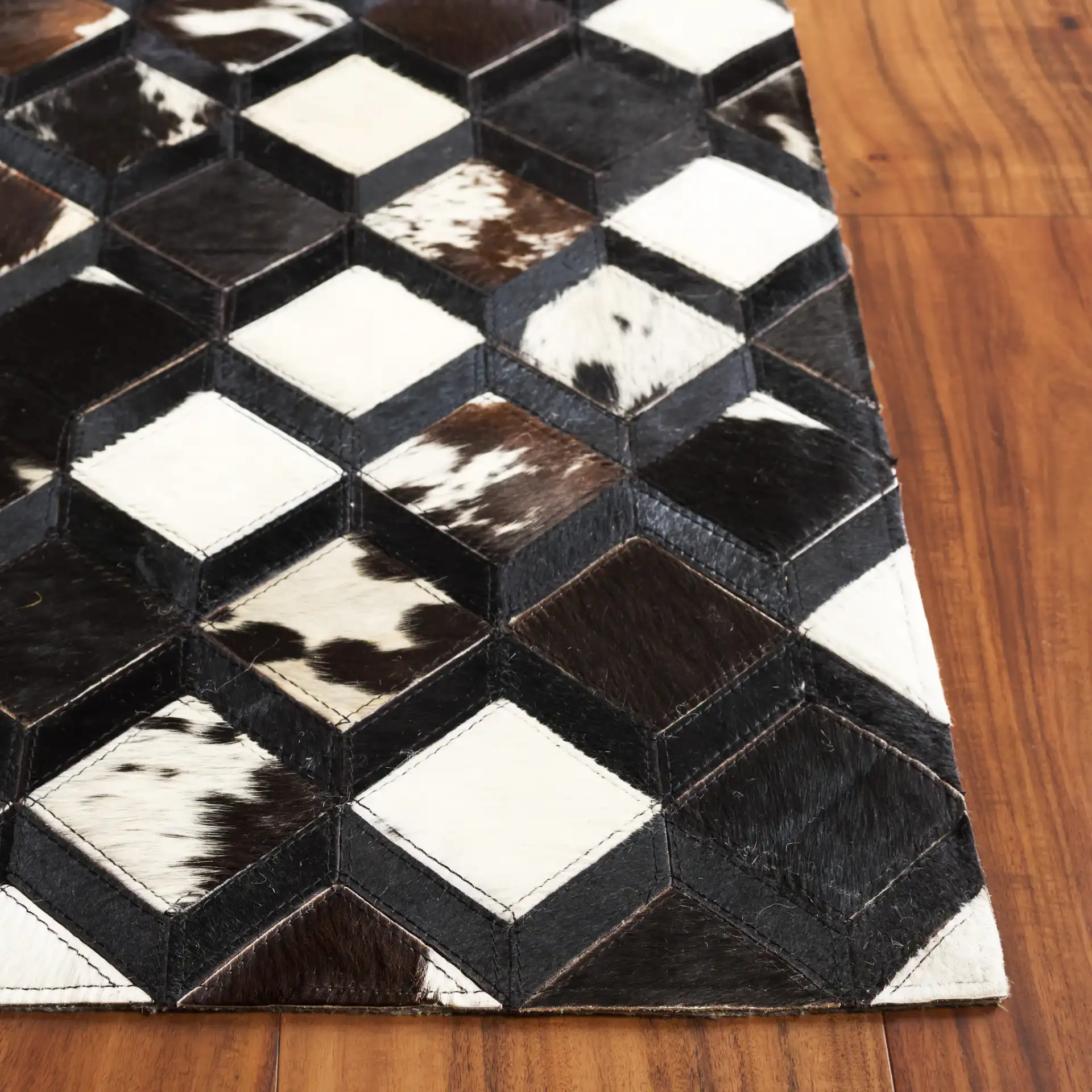 Studio Leather Diamond Patchwork Hand-Woven Rug in Black / Ivory in a styled room