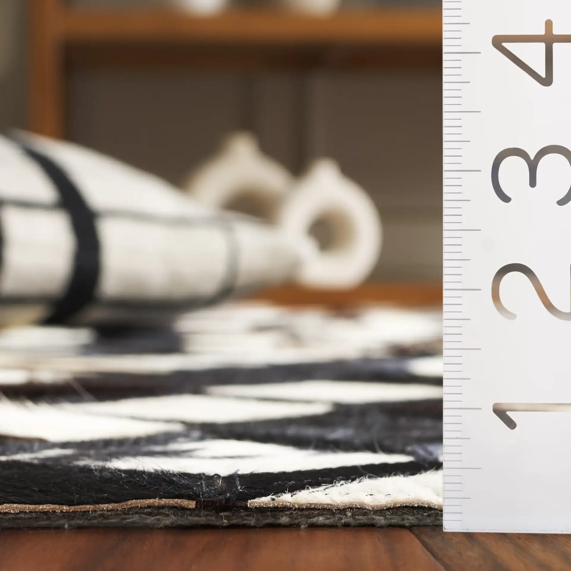 Studio Leather Diamond Patchwork Hand-Woven Rug in Black / Ivory in a styled room