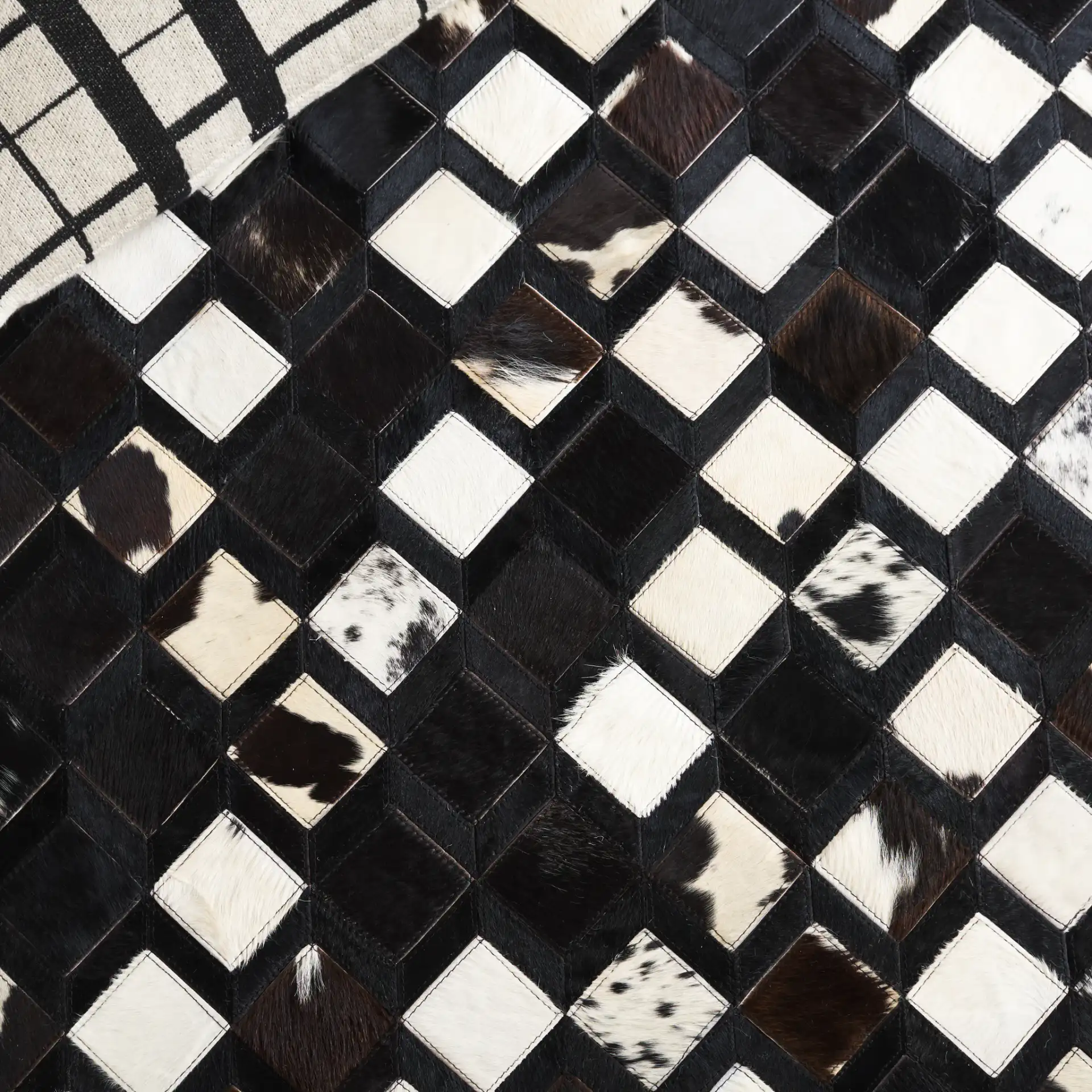 Studio Leather Diamond Patchwork Hand-Woven Rug in Black / Ivory in a styled room