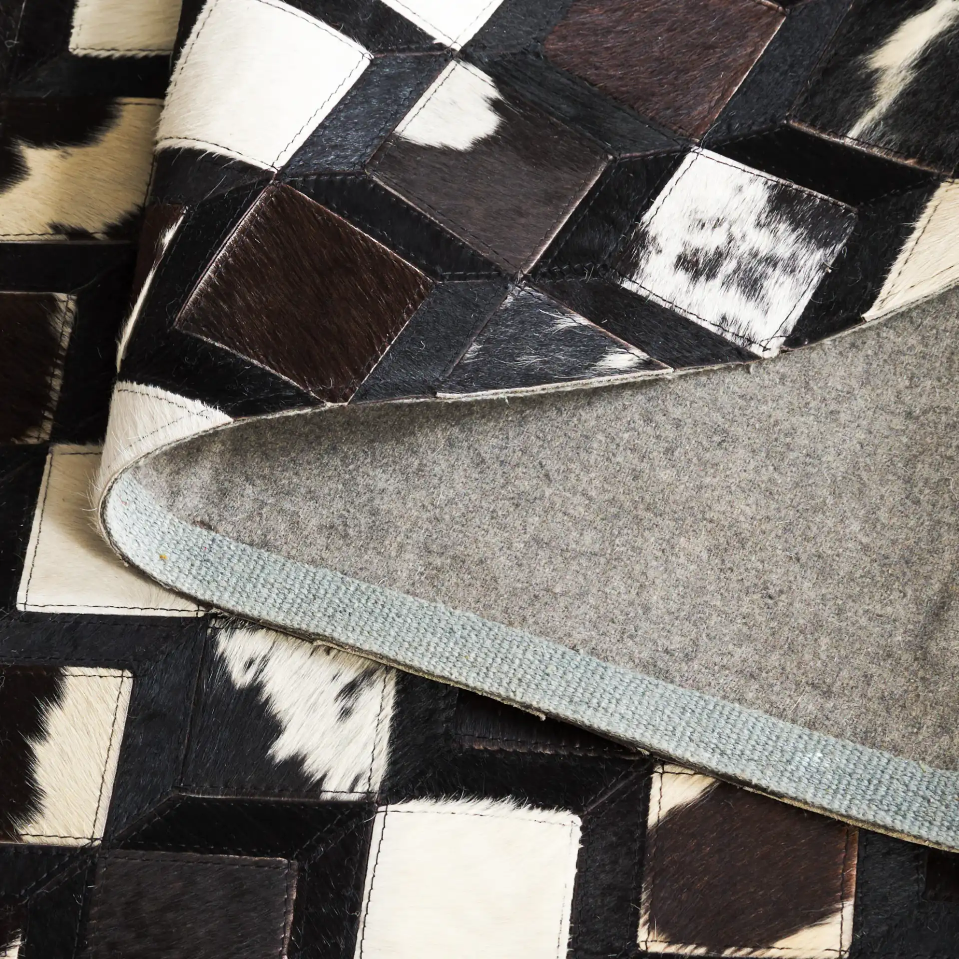Studio Leather Diamond Patchwork Hand-Woven Rug in Black / Ivory in a styled room
