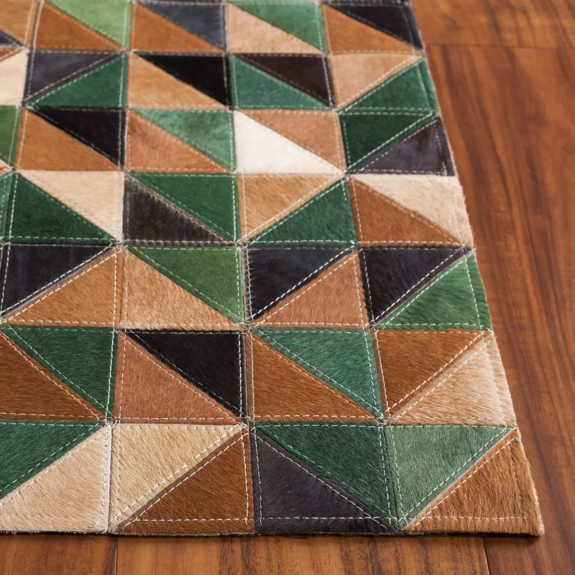 Studio Leather Modern Patchwork Geometric Hand-Woven Rug in Green / Light Brown in a styled room