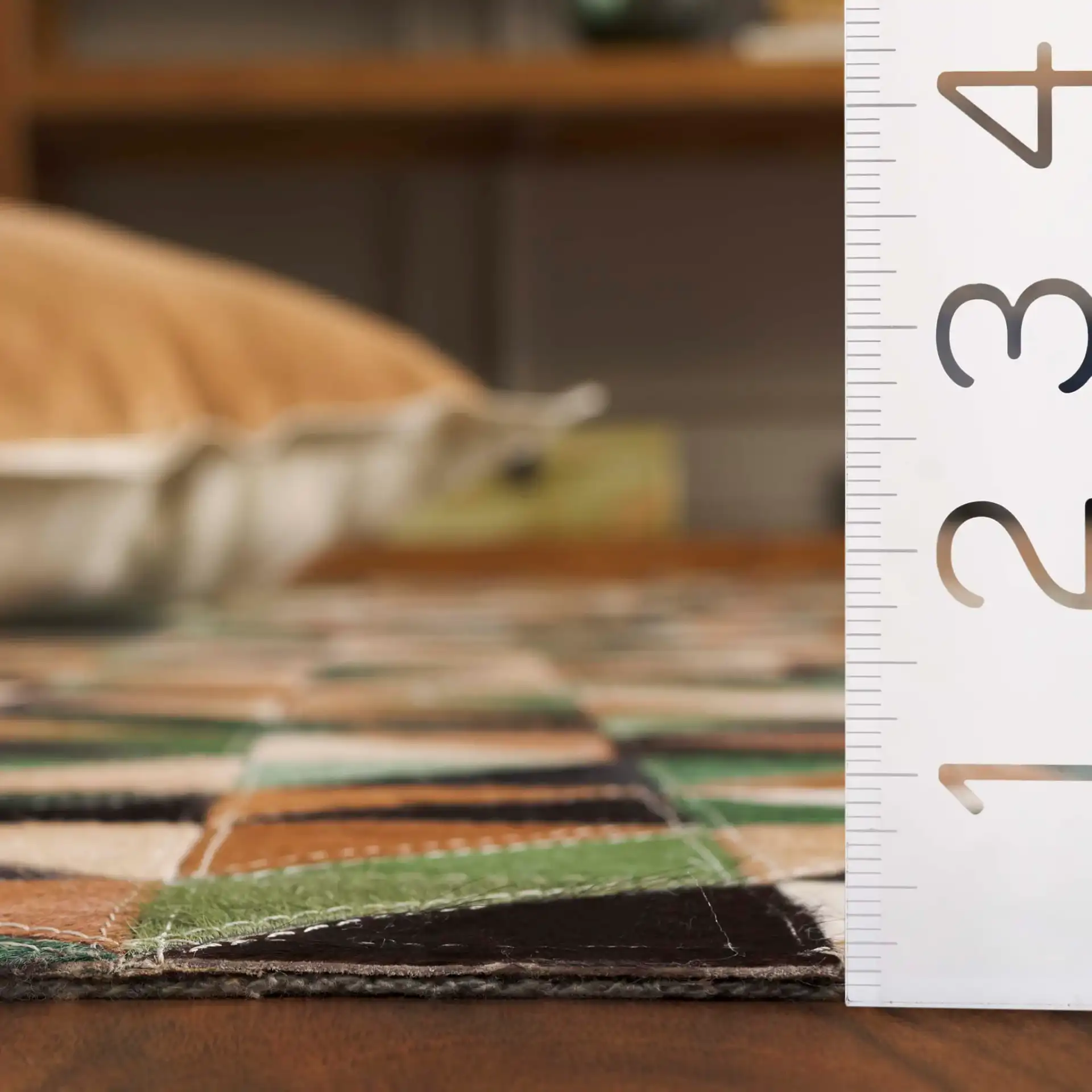 Studio Leather Modern Patchwork Geometric Hand-Woven Rug in Green / Light Brown in a styled room