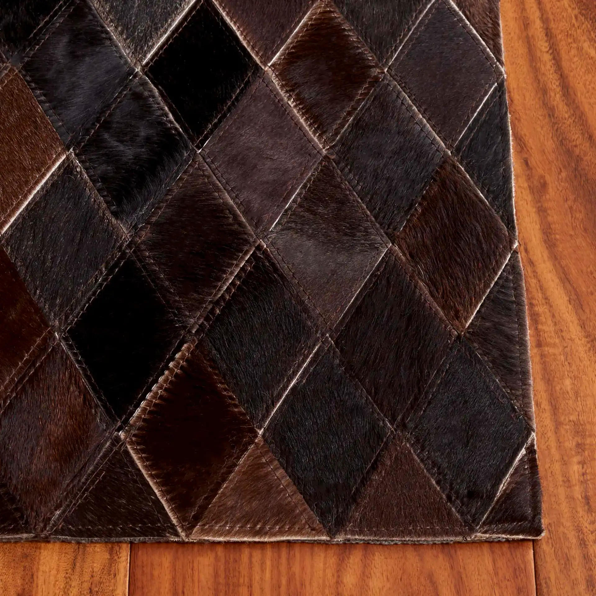 Studio Leather Harlequin Patchwork Hand-Woven Rug in Brown / Charcoal in a styled room