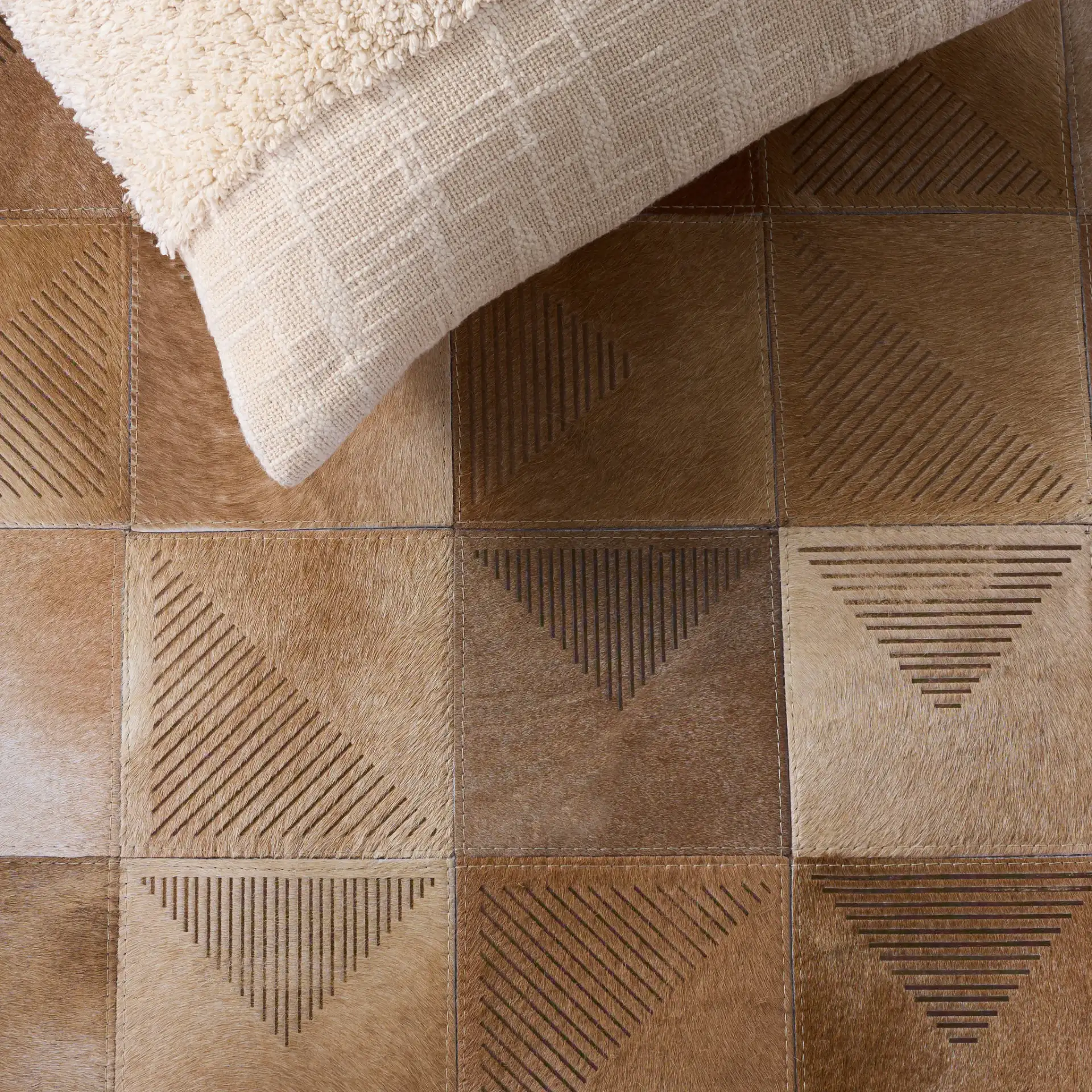 Studio Leather Geometric Patchwork Hand-Woven Rug in Beige / Brown in a styled room