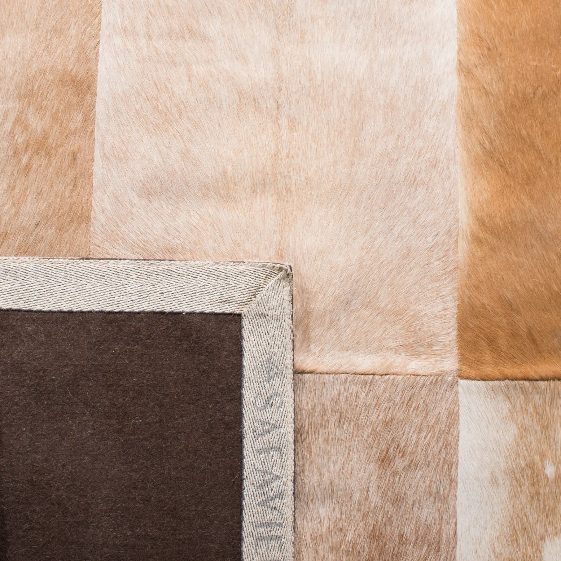 Studio Leather Patchwork Geometric Hand-Woven Rug in Beige / Brown in a styled room