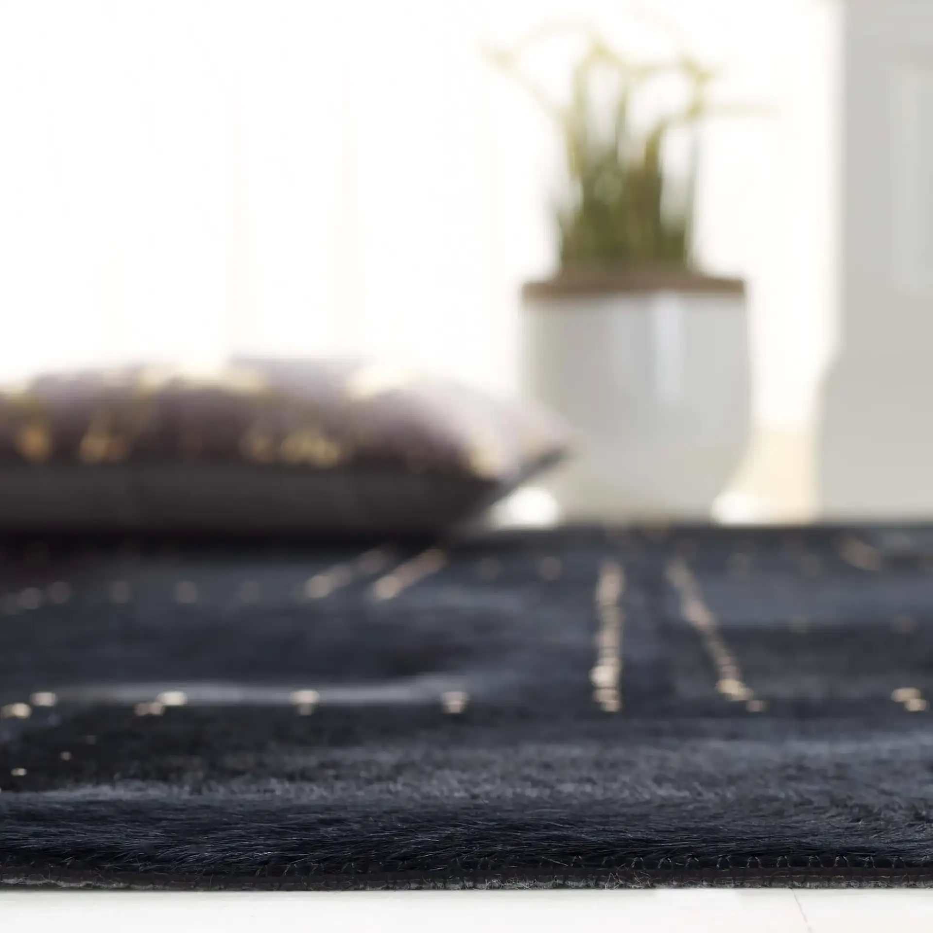 Studio Leather Stitched Patchwork Hand-Woven Rug in Black in a styled room