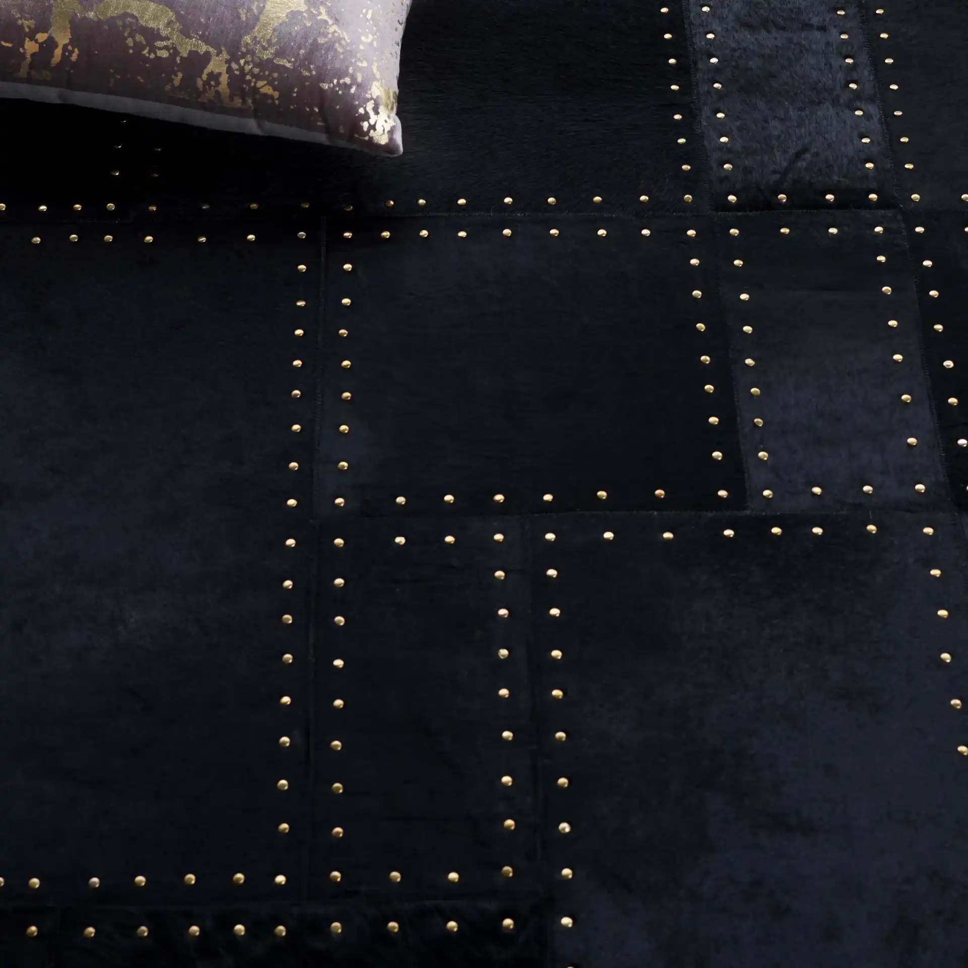 Studio Leather Stitched Patchwork Hand-Woven Rug in Black in a styled room