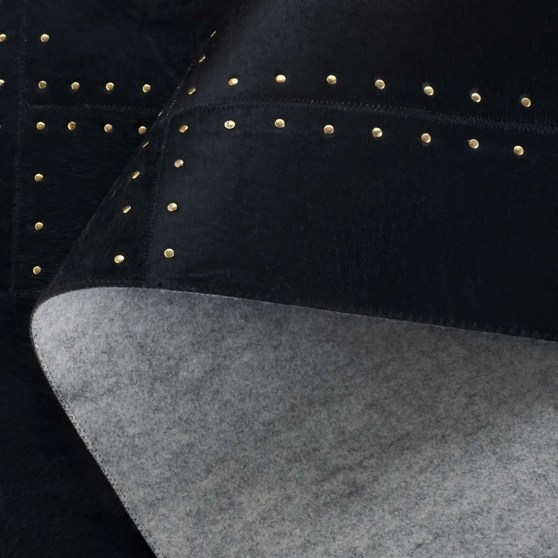 Studio Leather Stitched Patchwork Hand-Woven Rug in Black in a styled room