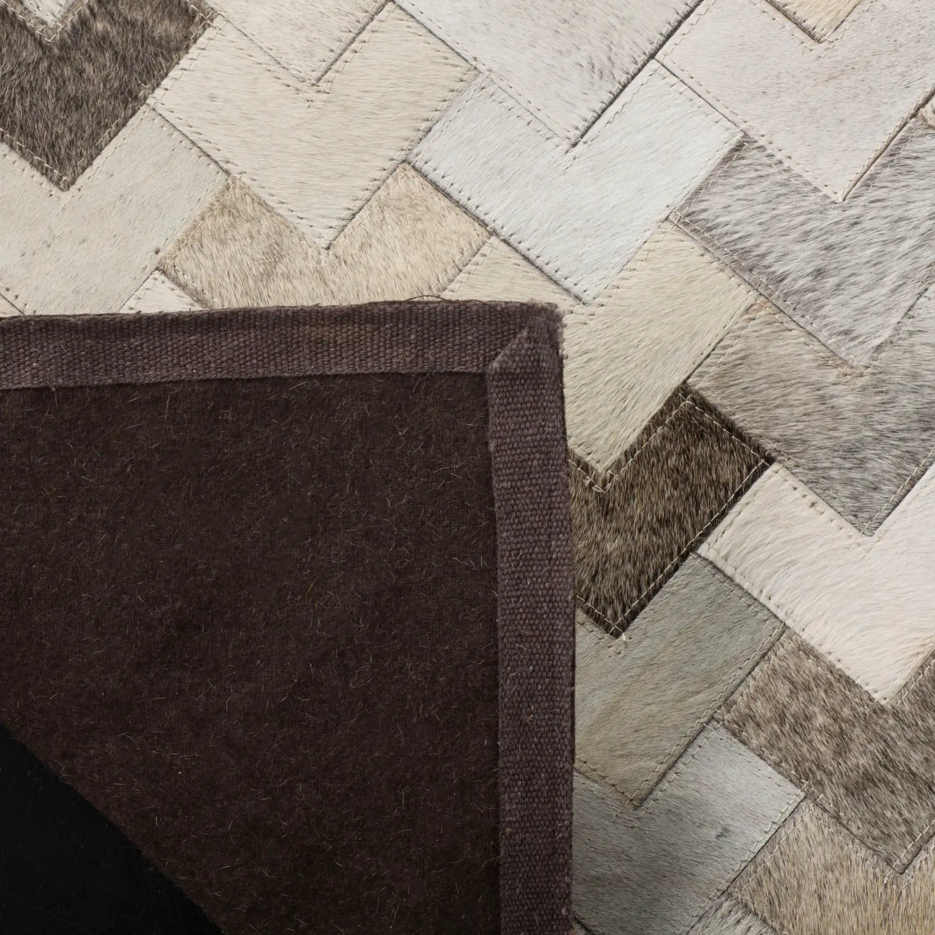 Studio Leather Chevron Patchwork Hand-Woven Rug in Gray in a styled room