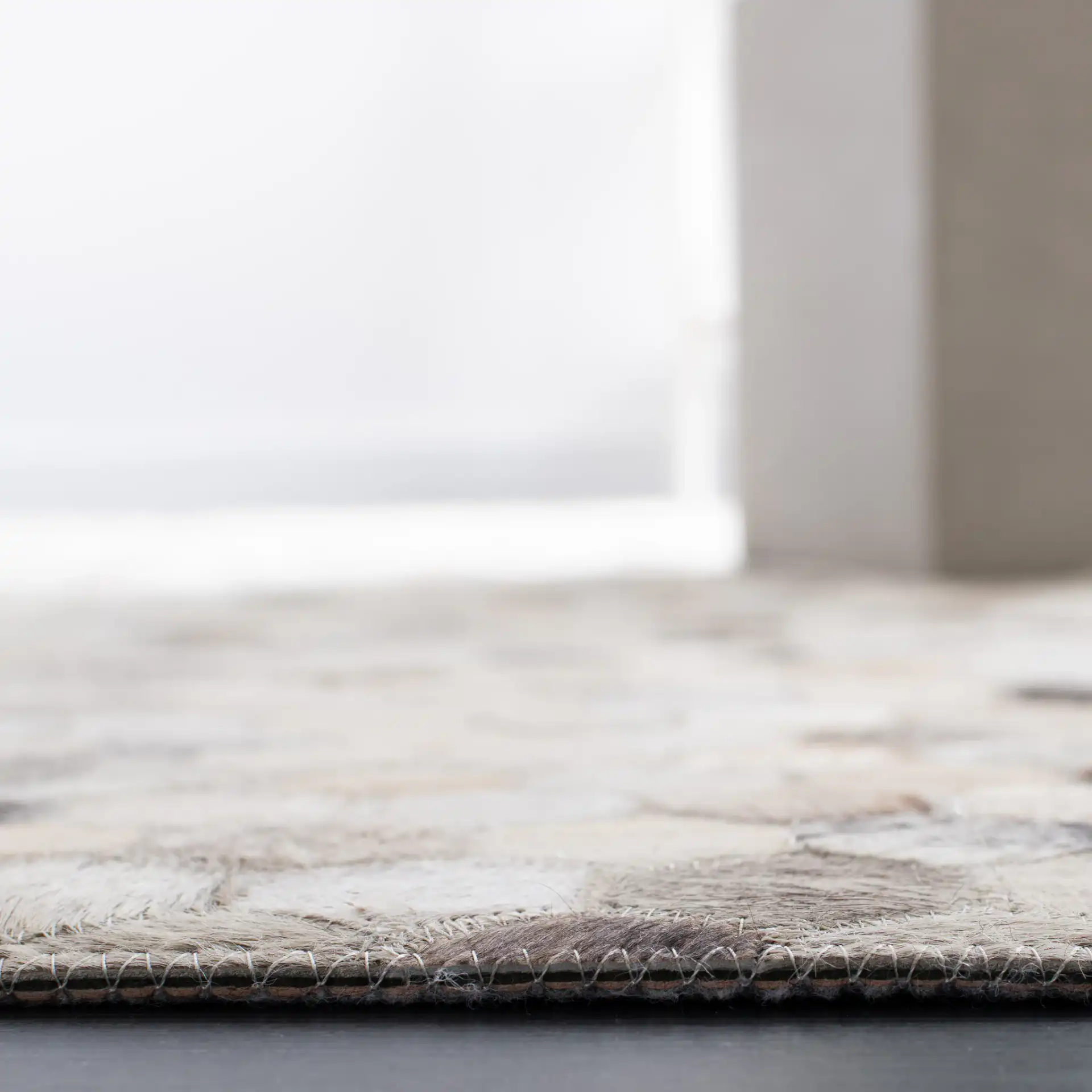 Studio Leather Honeycomb Patchwork Hand-Woven Rug in Ivory / Gray in a styled room