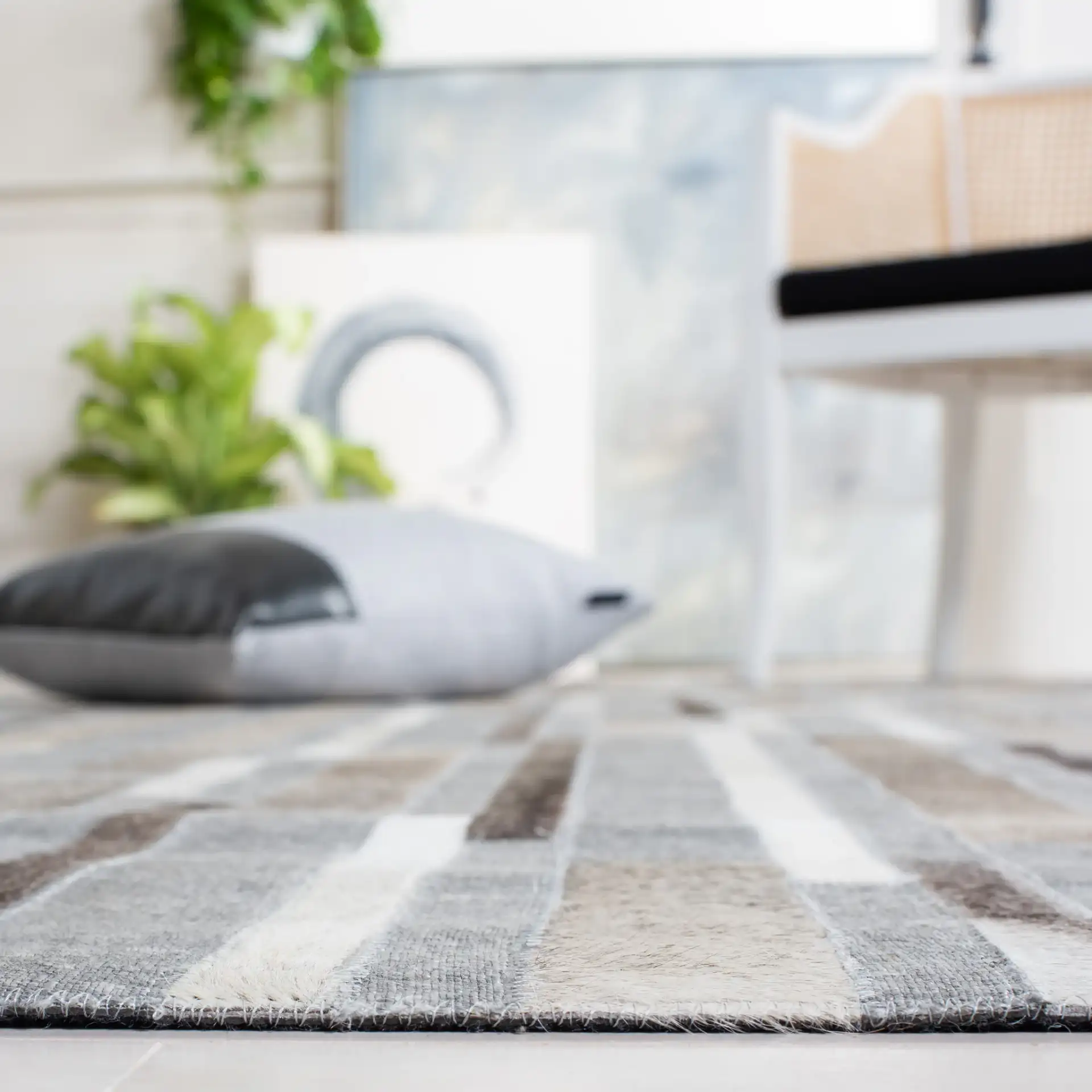 Studio Leather Linear Patchwork Hand-Woven Rug in Ivory / Gray in a styled room