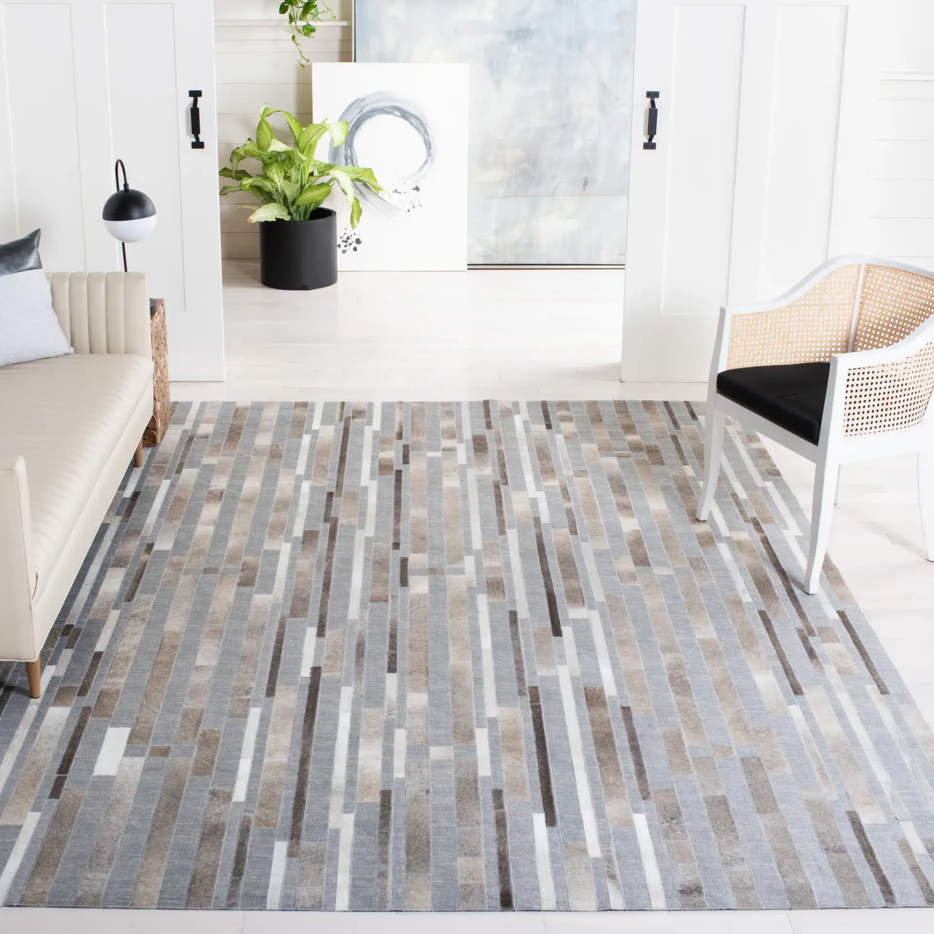 Studio Leather Linear Patchwork Hand-Woven Rug in Ivory / Gray in a styled room