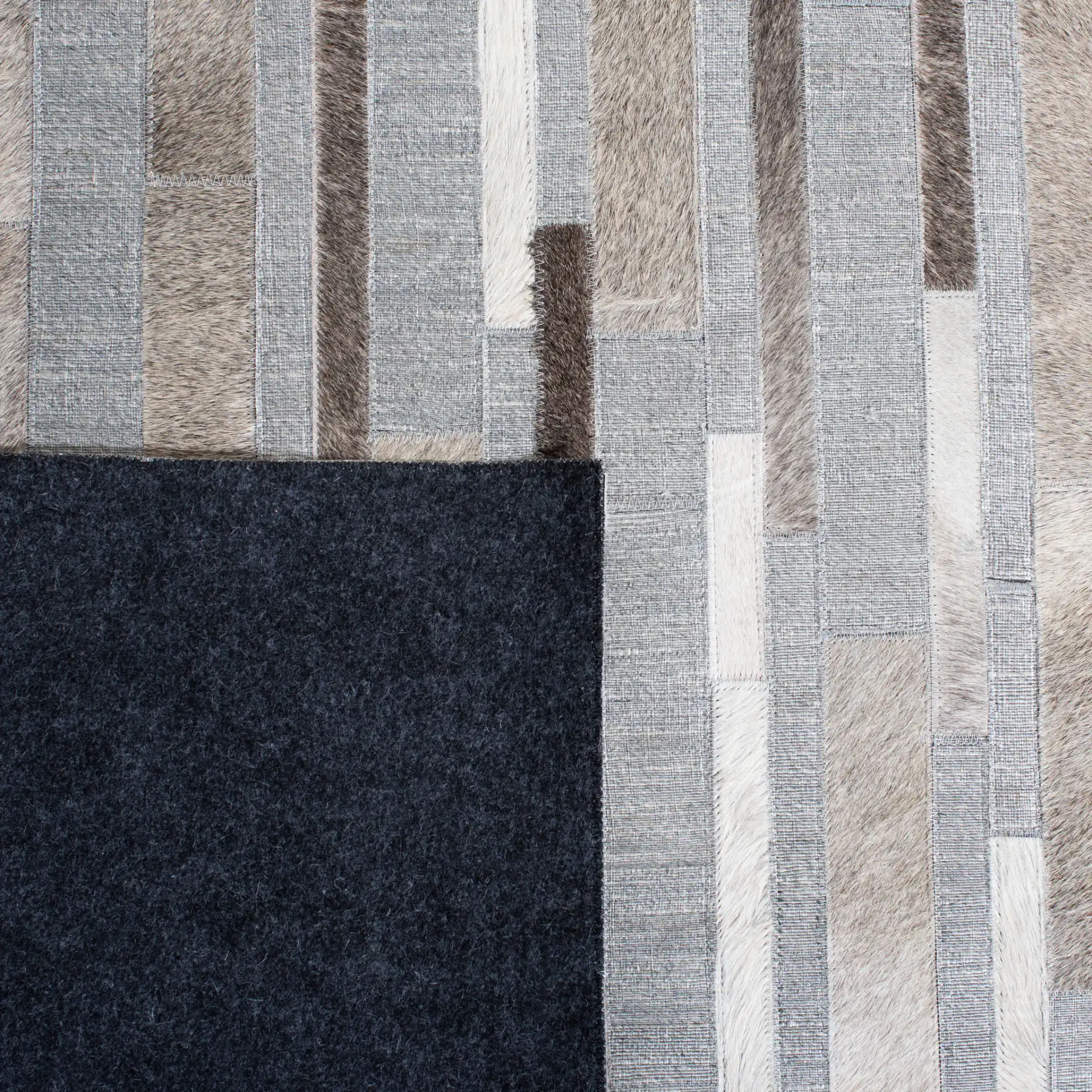 Studio Leather Linear Patchwork Hand-Woven Rug in Ivory / Gray in a styled room