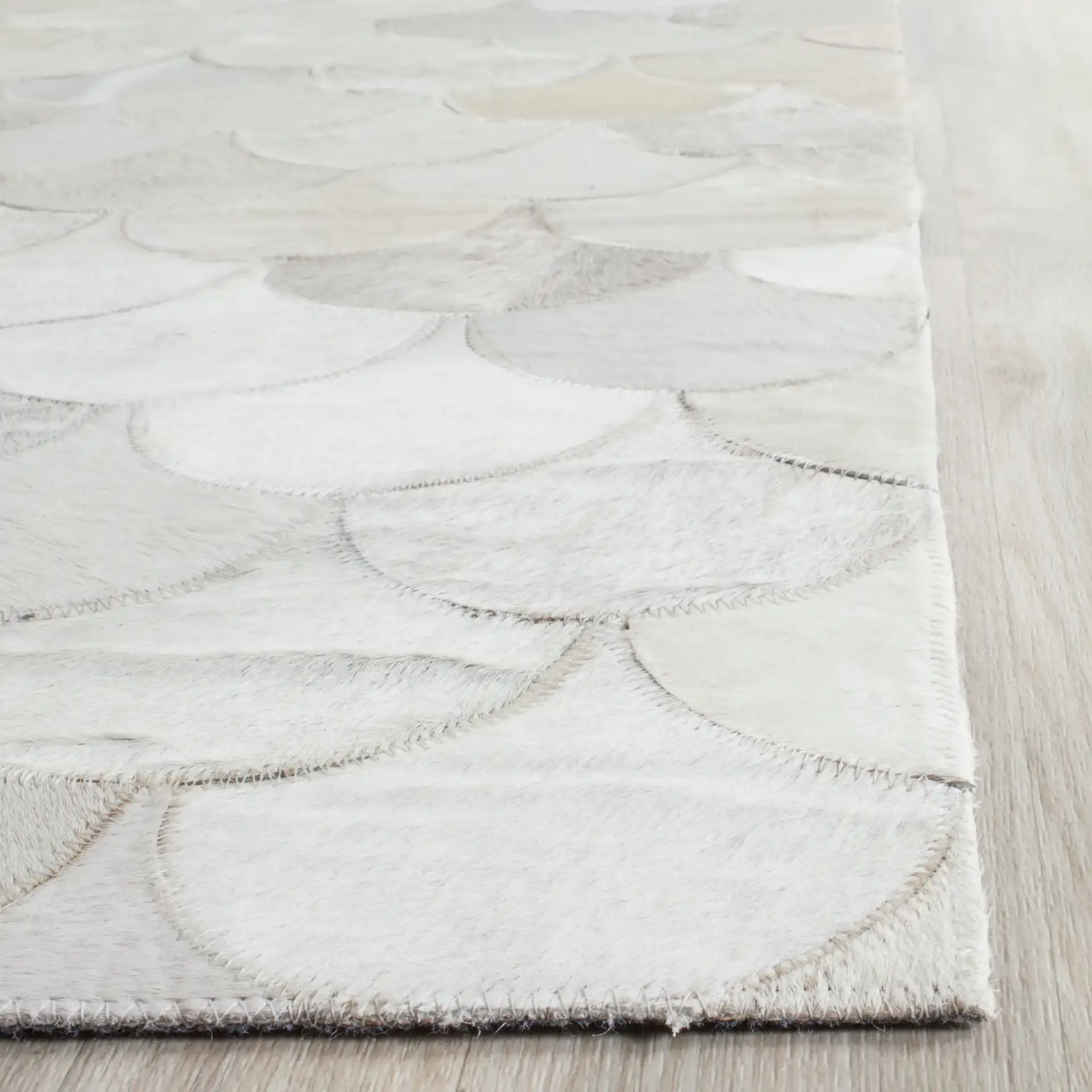 Studio Leather Fish Scale Patchwork Hand-Woven Rug in Ivory / Gray in a styled room